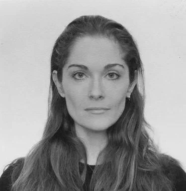 Black and white portrait of a woman with long hair. She has a serious expression and is looking directly at the camera.
