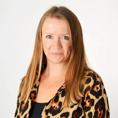 Portrait of a person with long hair wearing a leopard print shirt.