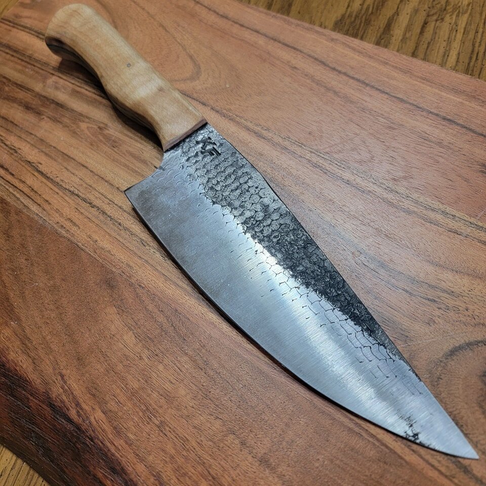 Forged rasp chefy! Natural curly maple handle and a stainless steel pin! This thing is razor sharp! And just amazing to use!

The handle is beyond comfortable! Using a hand made knifes is a game changer I promise you! Get yours at Kinseyforge.com
You