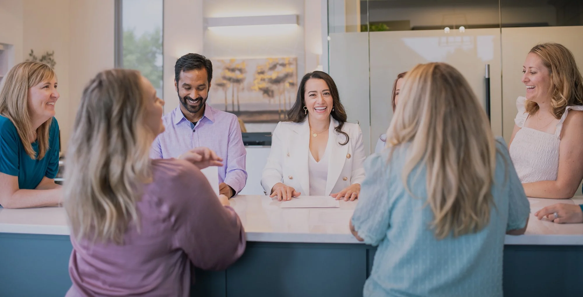Alive Dental team meeting around a table discussing their rebrand strategy and business growth plans as part of their exit-ready branding transformation.