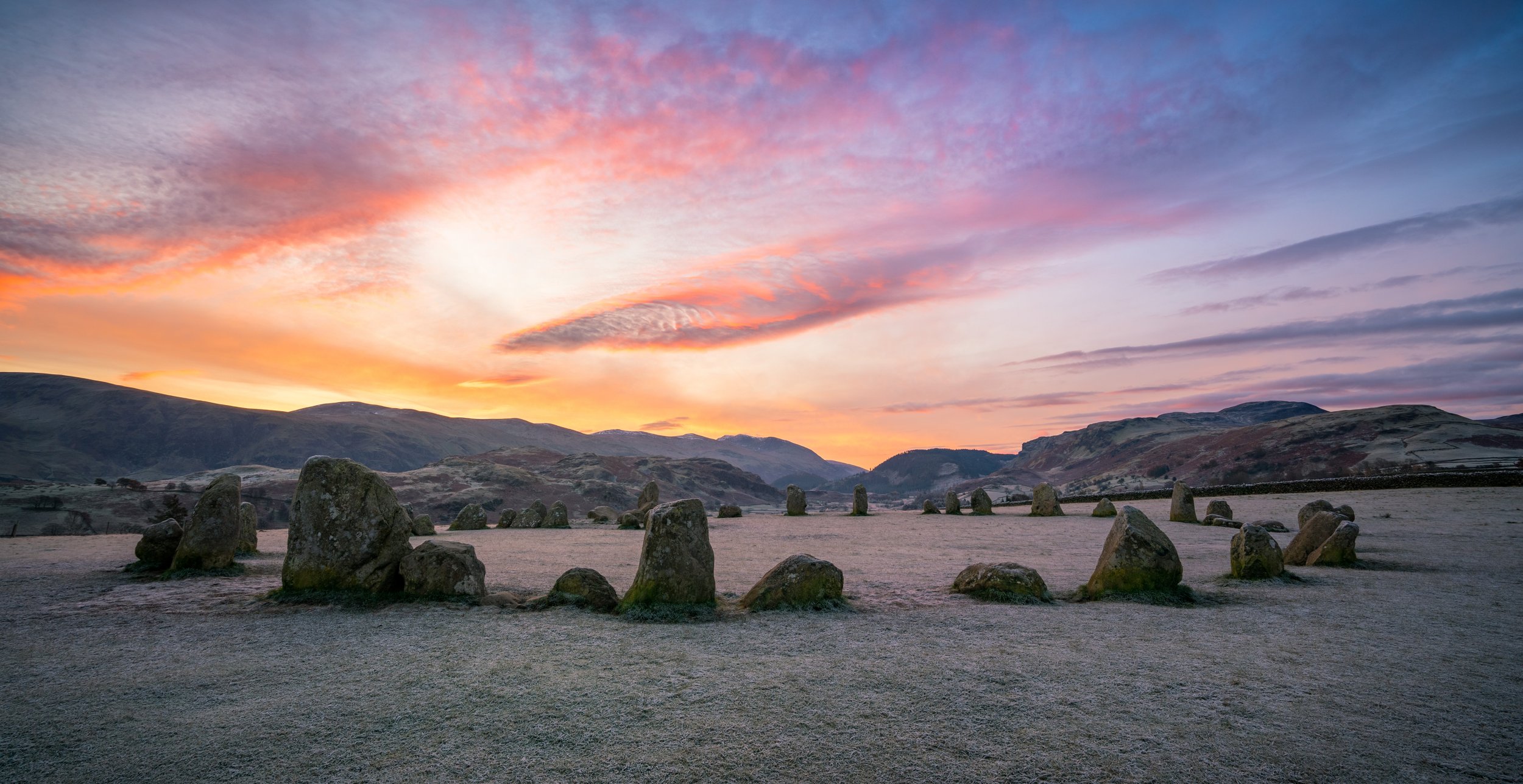 A stunning colourful winter sunrise by the ancient Castlerigg Stone Circle in the Lake District near Keswick