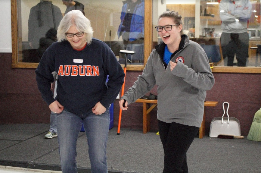  Alyson Wiedenbeck and a participant share a laugh during the Celebrity Curler Outreach learn-to-curl in 2018. 