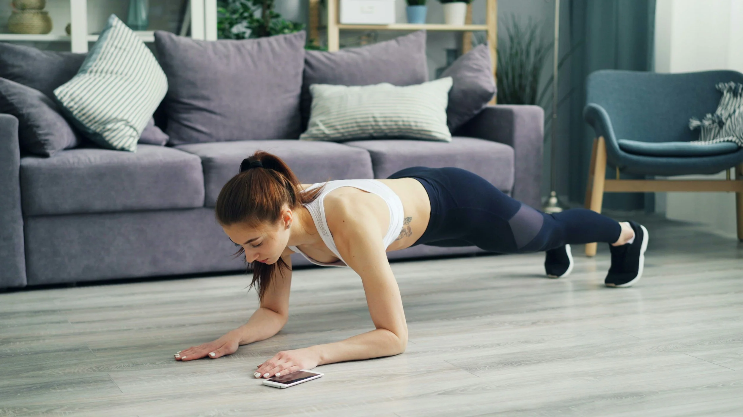 Woman doing bodyweight strength training at home to build strength without a gym