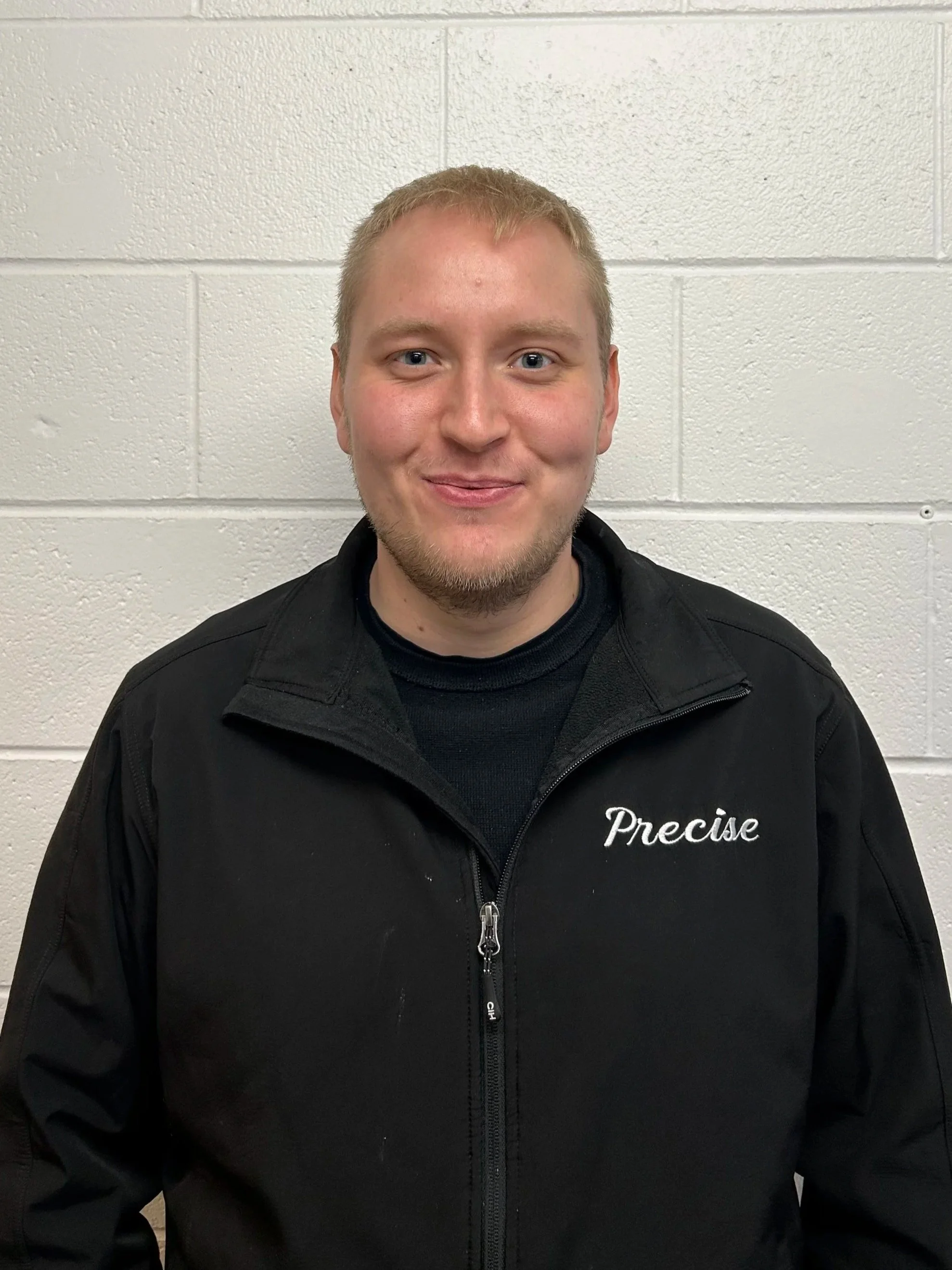 Blonde man with a black jacket in mechanic shop
