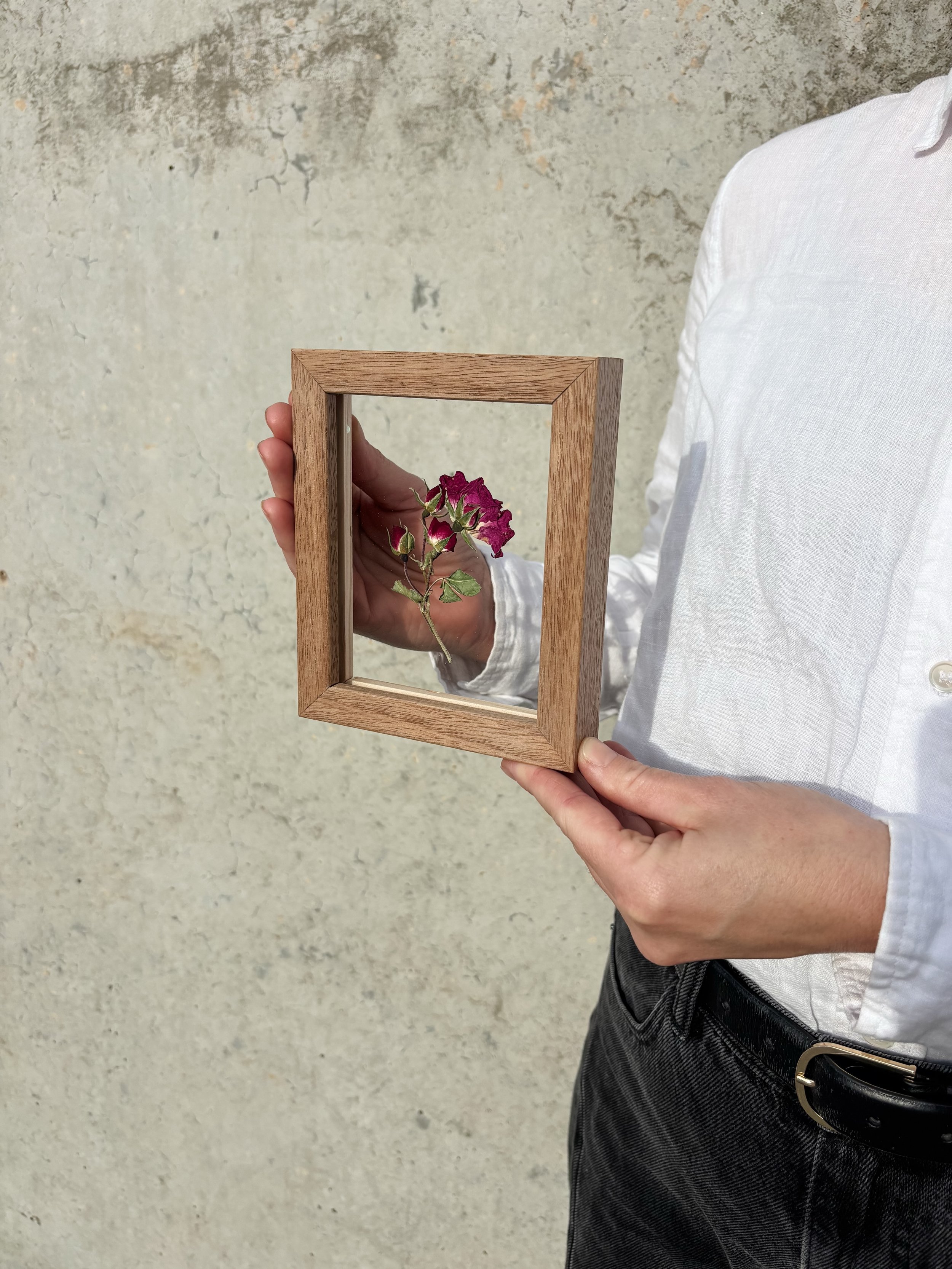 It started with a single tiny flower. 

A customer came into the studio with the tiniest sentimental flower and asked if we could create an equally tiny frame for it.
We made one, sat it on the shelf, and immediately fell in love.
No hooks, no fuss &