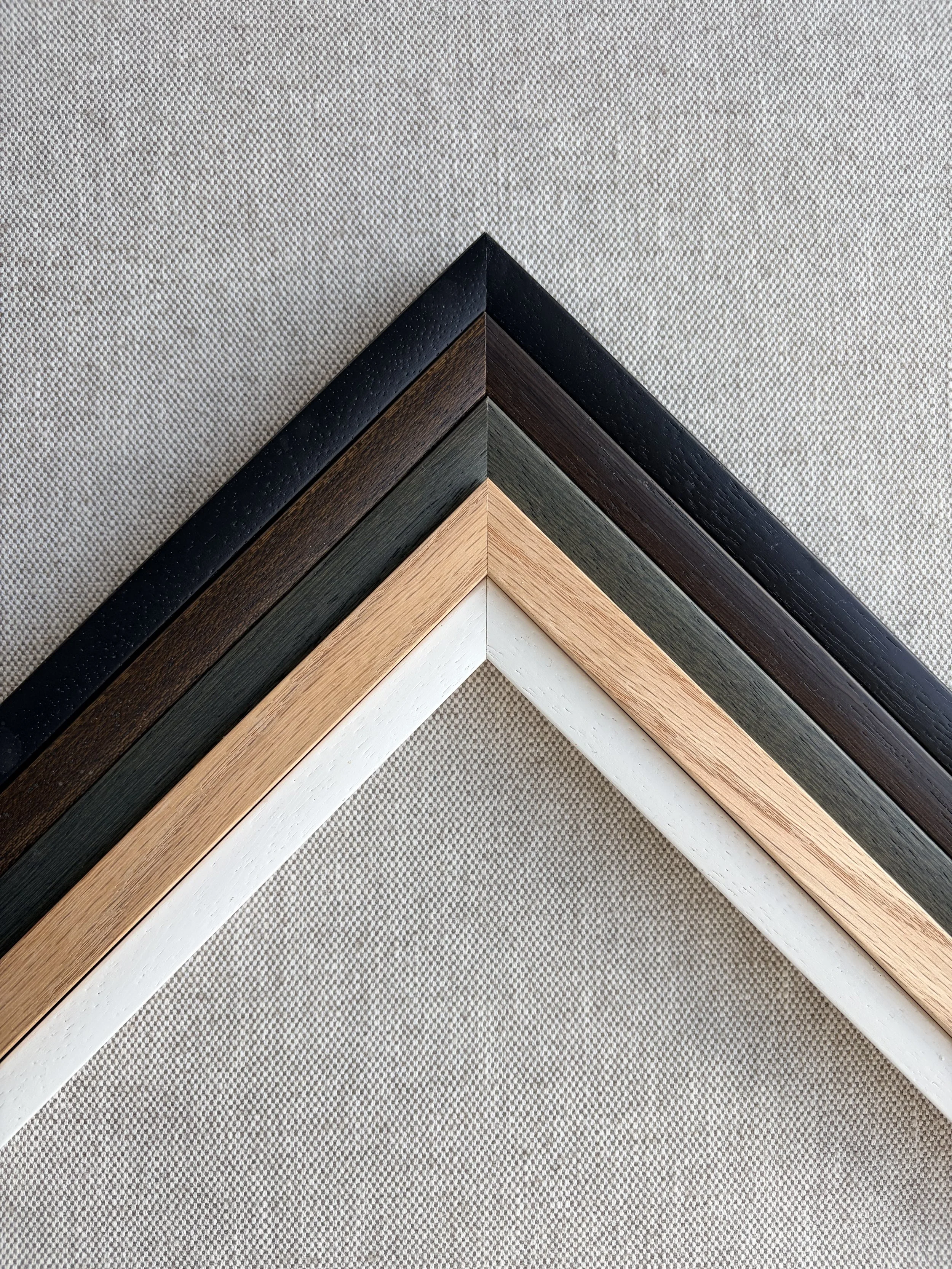 Close-up of four different colored wooden picture frame corners arranged to form a pattern.