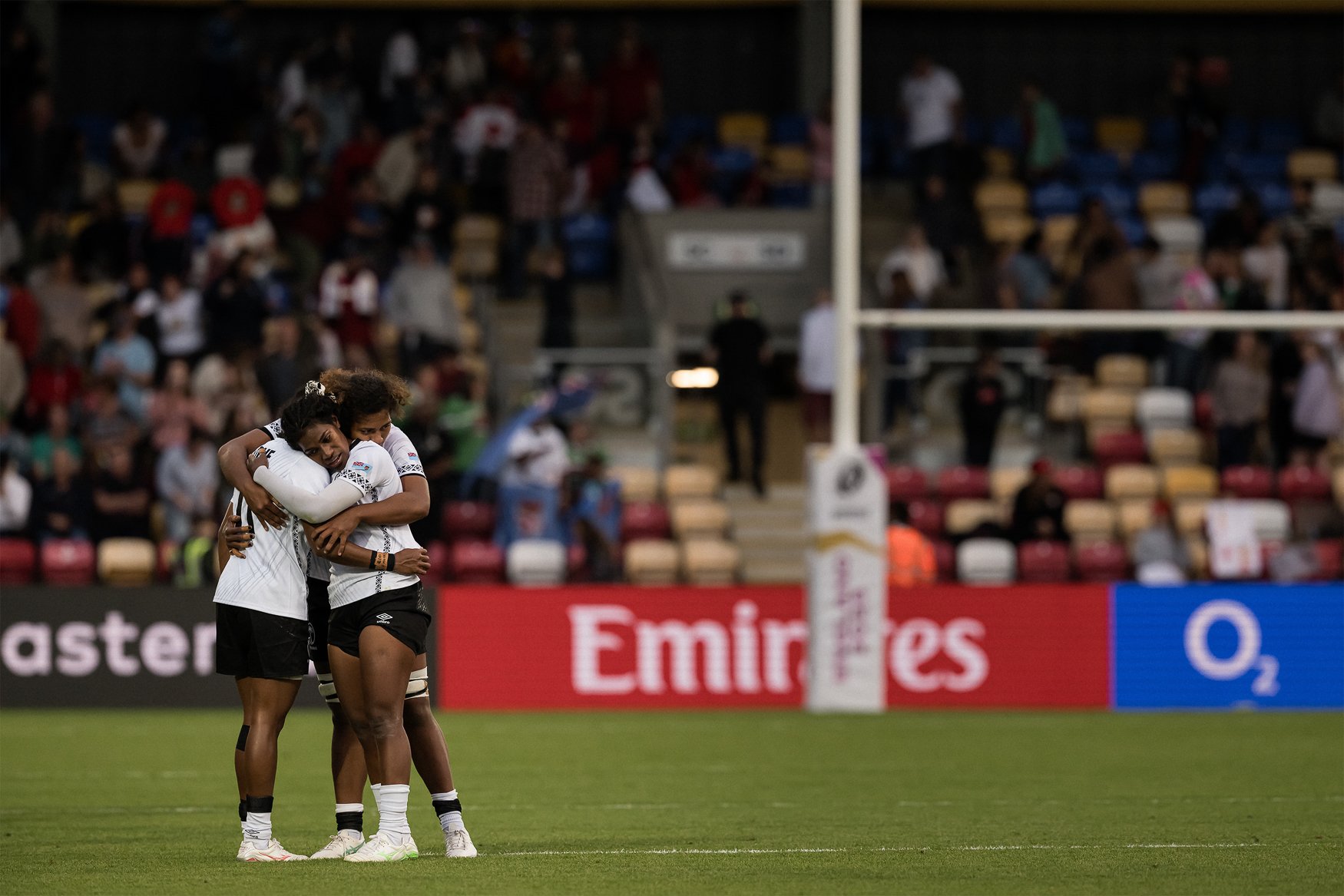 Fiji players comfort each other following defeat against canada