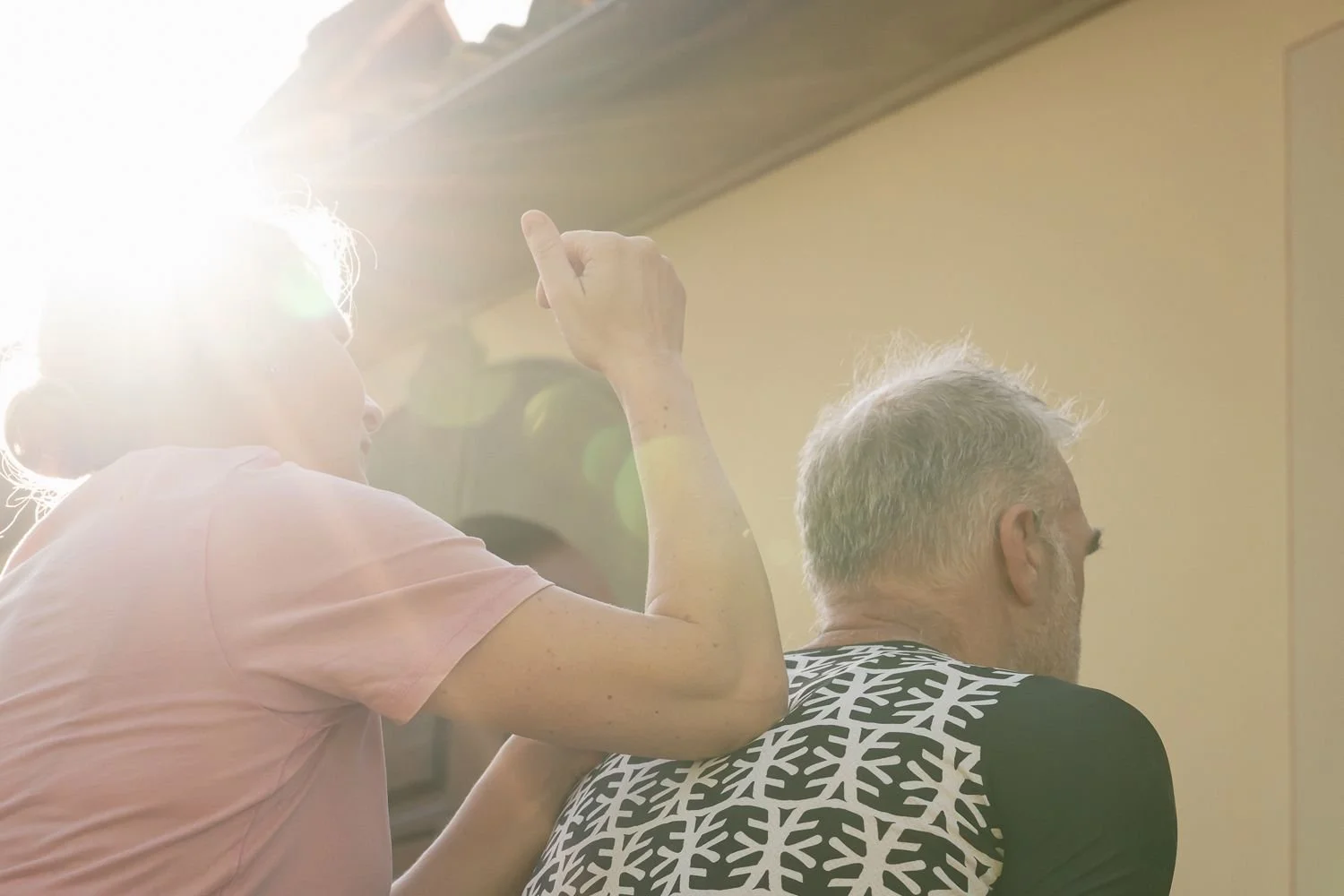 Two riders share a warm moment in strong backlight and sun flare