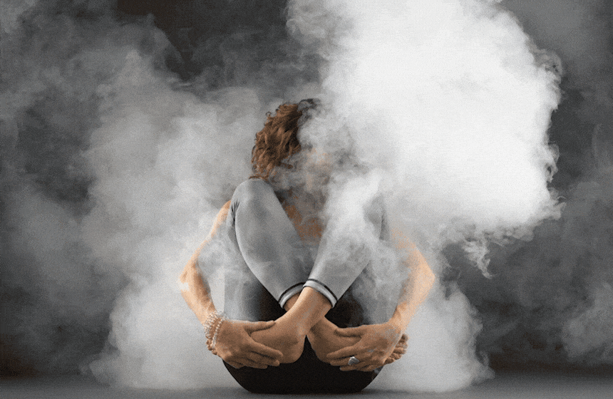 Yoga teacher Anna Ashby in a kneeling backbend, shot in studio with atmospheric haze