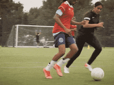 Women's football match seen through the goal net at a London pitch