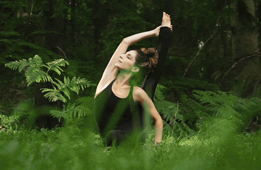 Yoga practitioner in a seated spinal twist on a wooden studio floor
