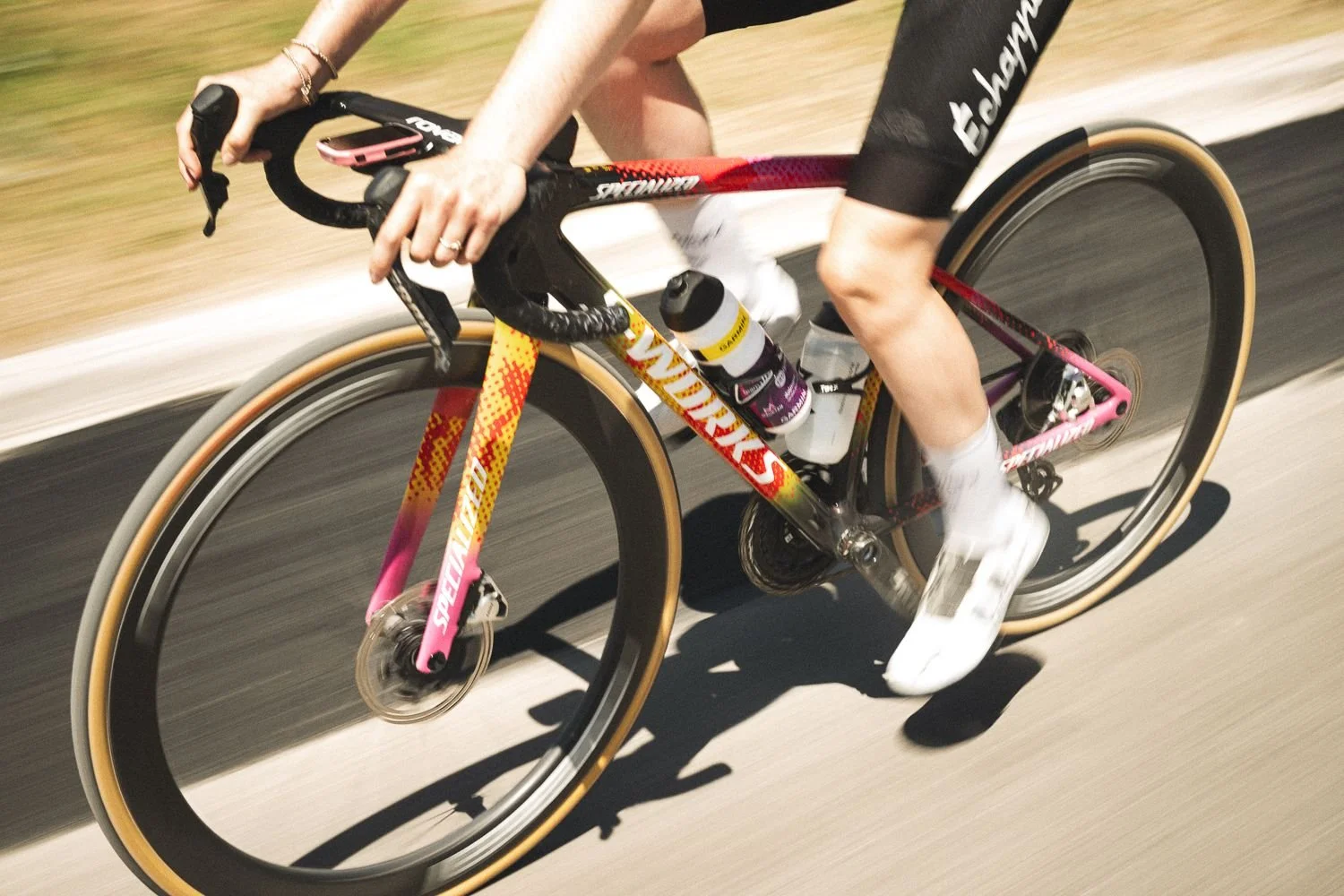 Low panning shot of a colourful bike frame and wheel in motion on the road