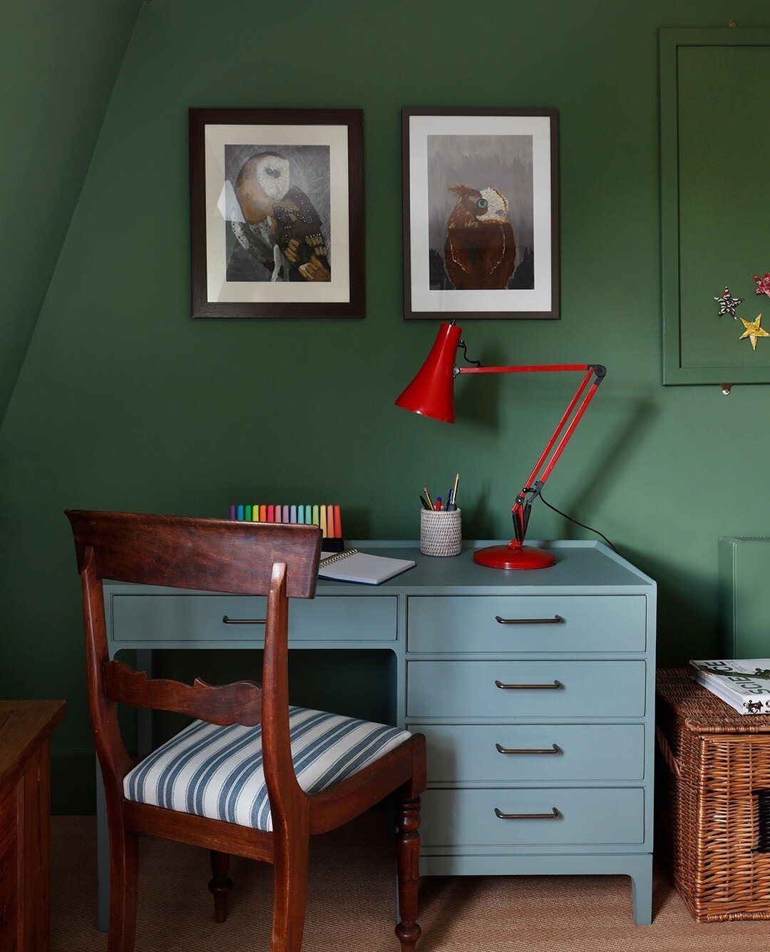 Studies show that children with an allocated work space do better at school.  In this attic bedroom, we chose dark green walls to create a calm and cosy feel for its teenage occupant, and used the client's own red lamp as a pop of colour to help focu