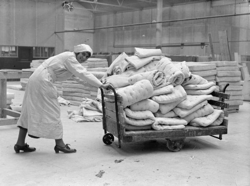 A female worker pushes a trolley of asbestos mattresses in a Lancashire factory during the First World War