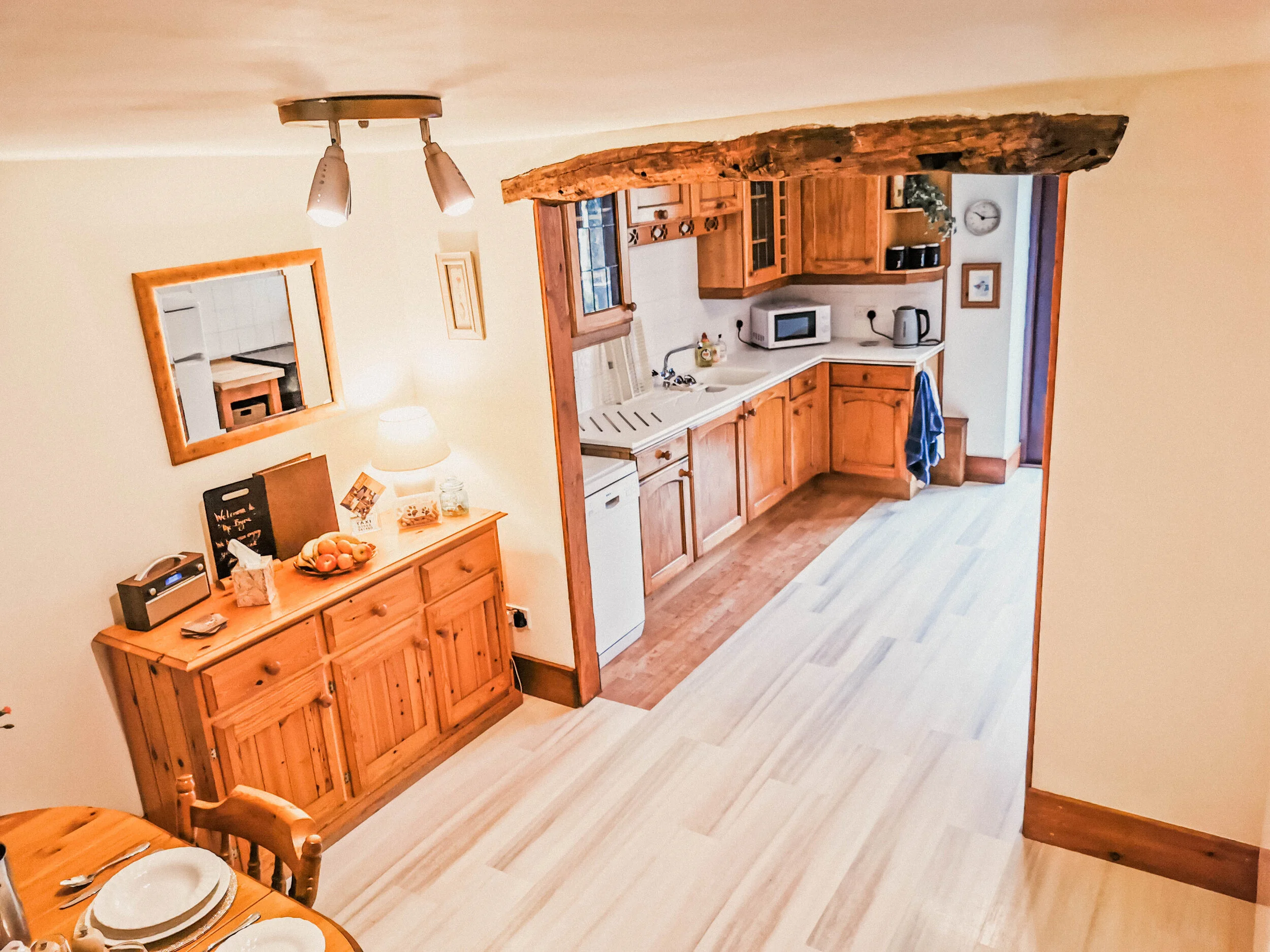 Open-plan kitchen space with fridge/freezer, cutlery, crockery, electric oven, kettle and microwave 