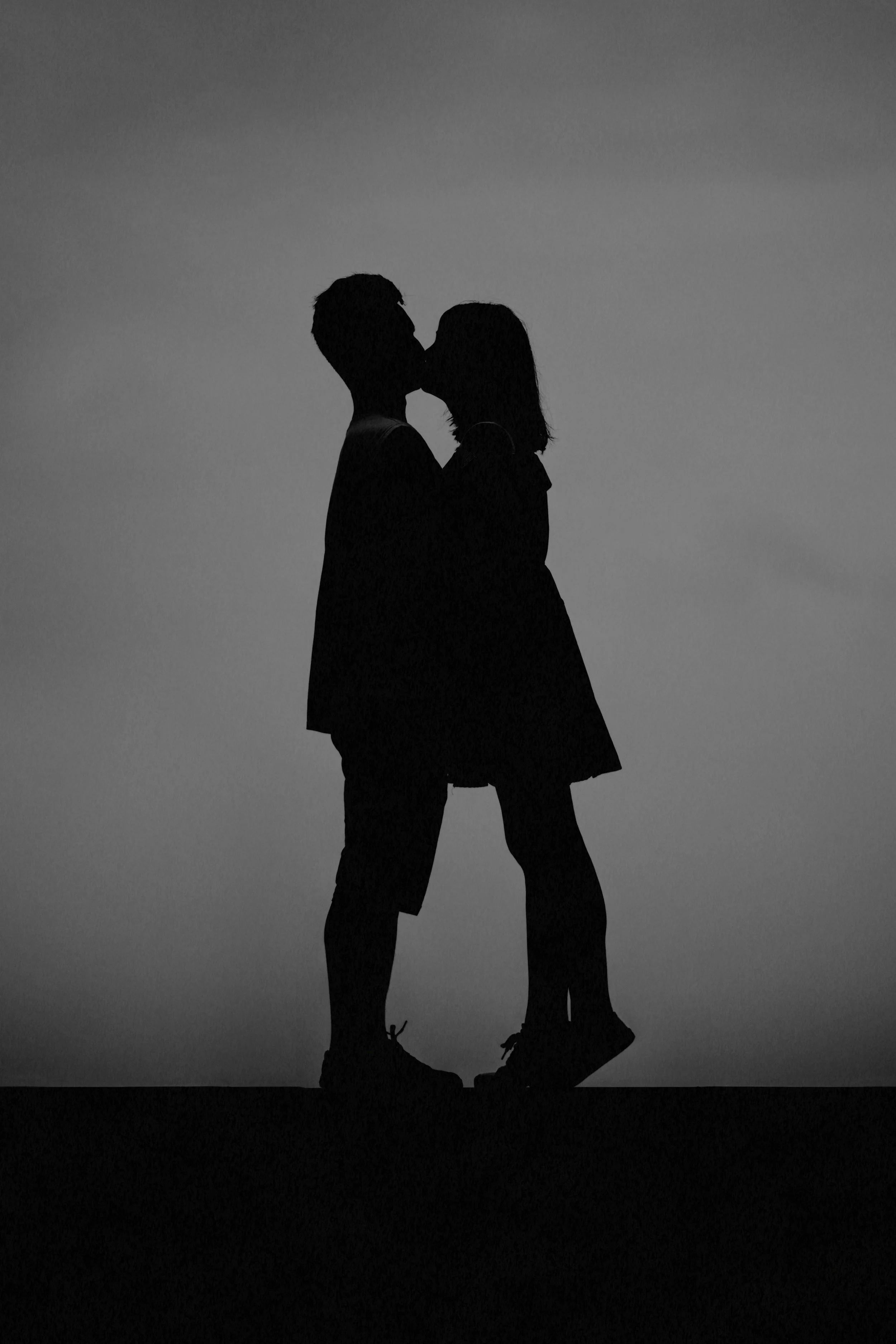 Silhouette of man and woman kissing