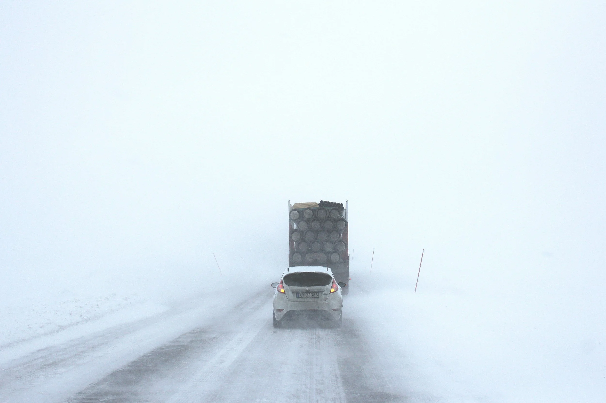Snow-covered highway with limited visibility during a winter storm, illustrating conditions that require rapid emergency lodging coordination supported by Lima Charlie Inc.