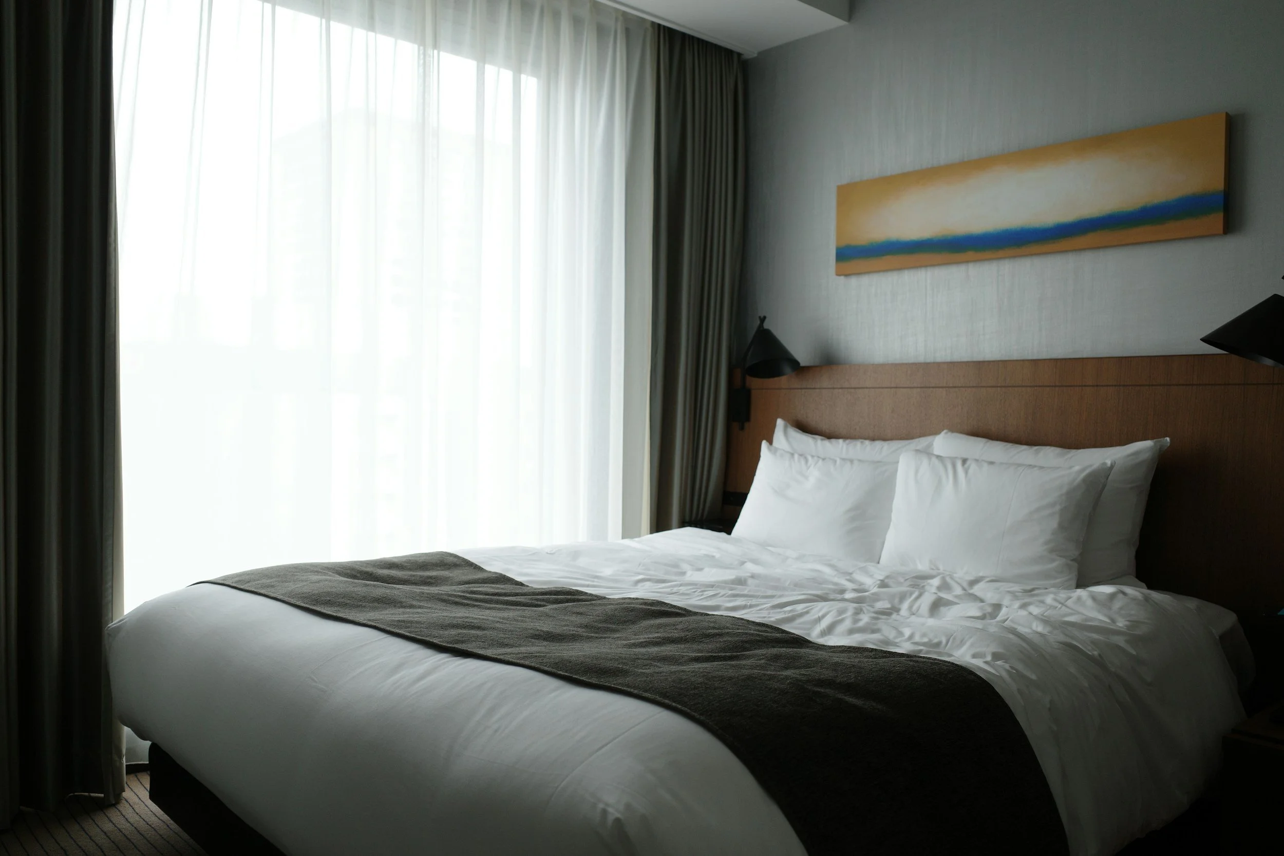 Modern furnished corporate housing bedroom illustrating move-in-ready extended-stay accommodations provided through Lima Charlie Inc.’s centralized lodging network.