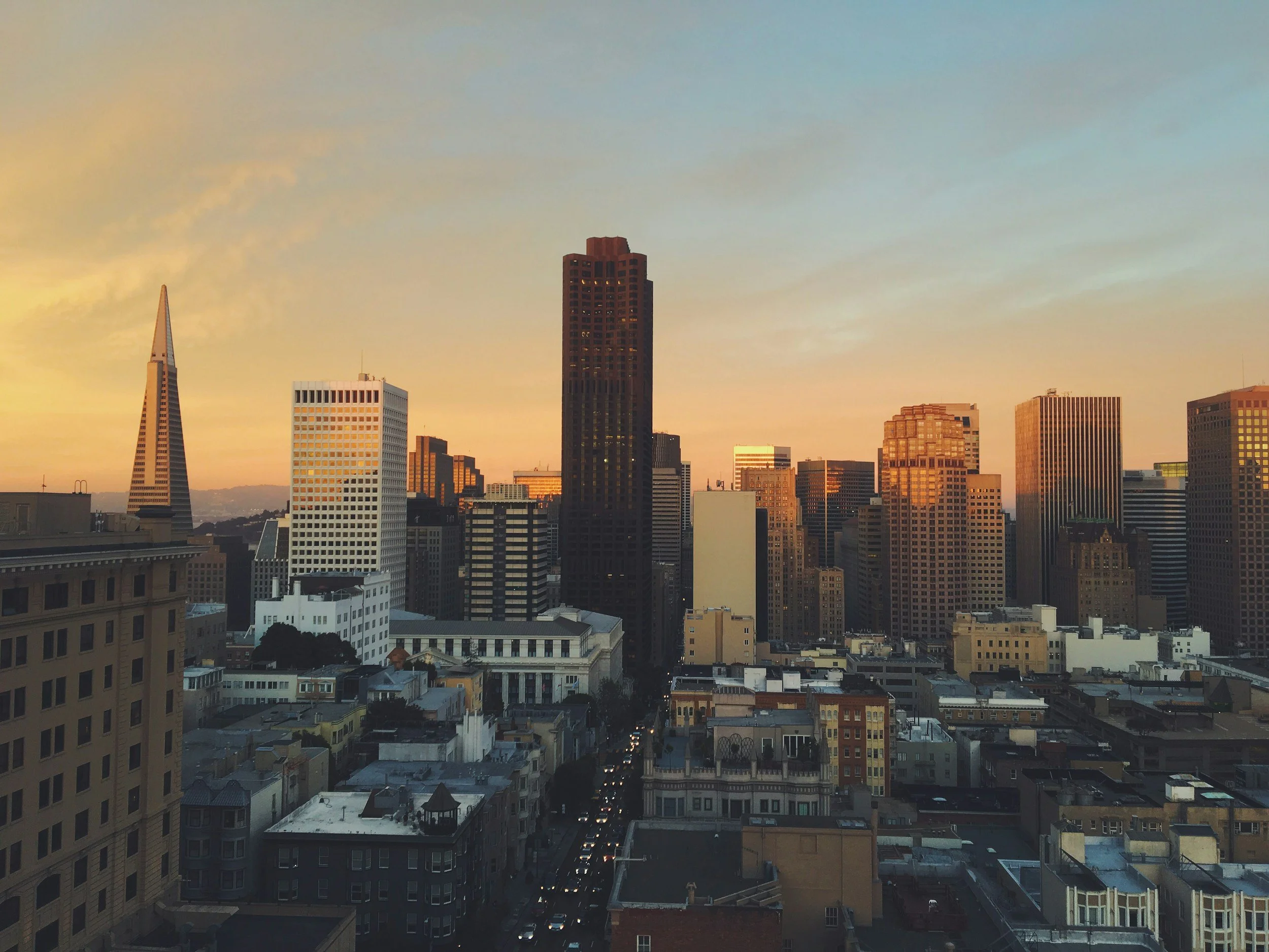 Aerial view of a major U.S. city skyline at sunset, representing Lima Charlie Inc.'s nationwide corporate lodging and workforce housing solutions available across urban markets.
