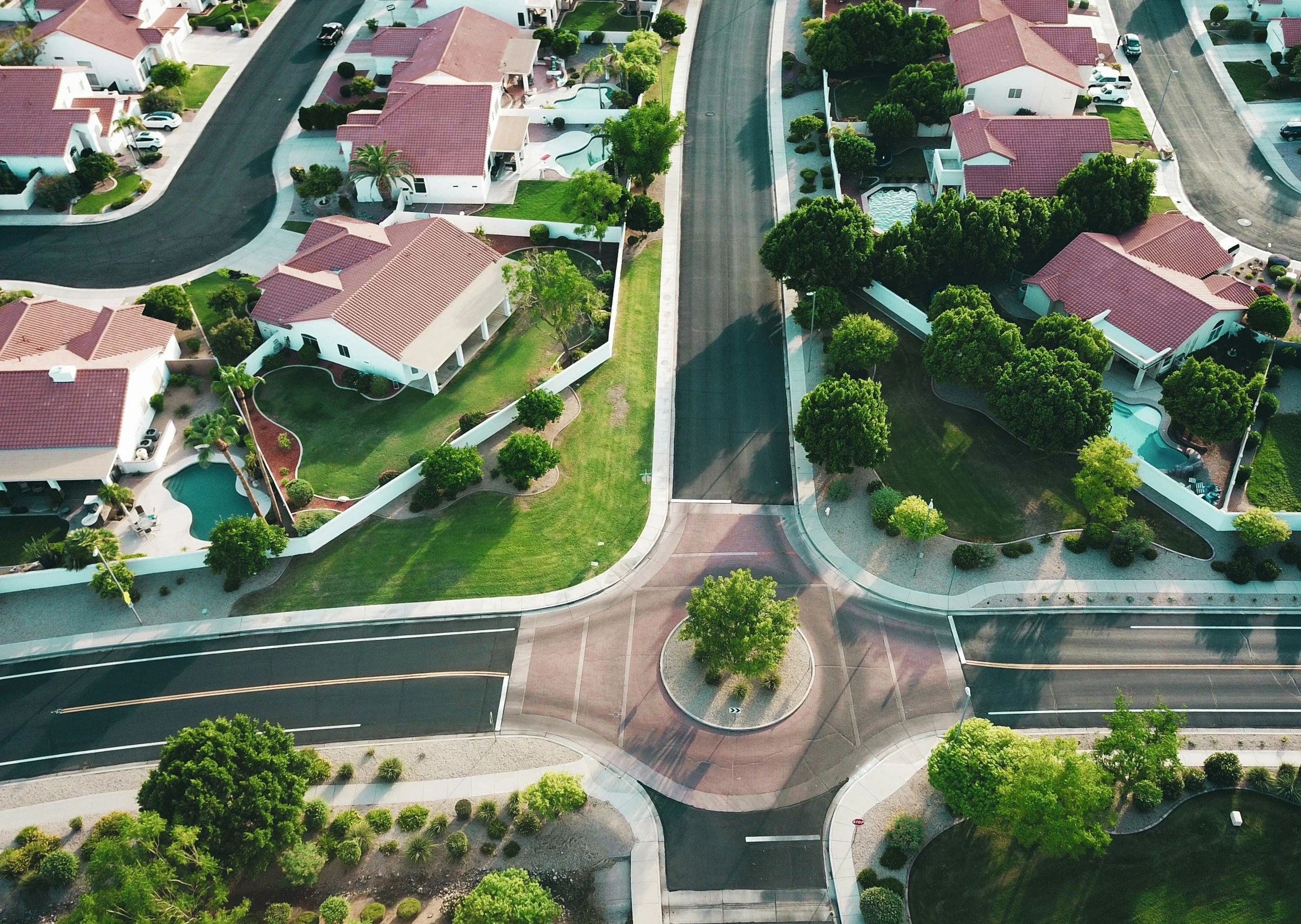 Aerial view of a suburban neighborhood with red tile roofs and tree-lined streets, similar to furnished housing units Lima Charlie Inc. places displaced families into nationwide.