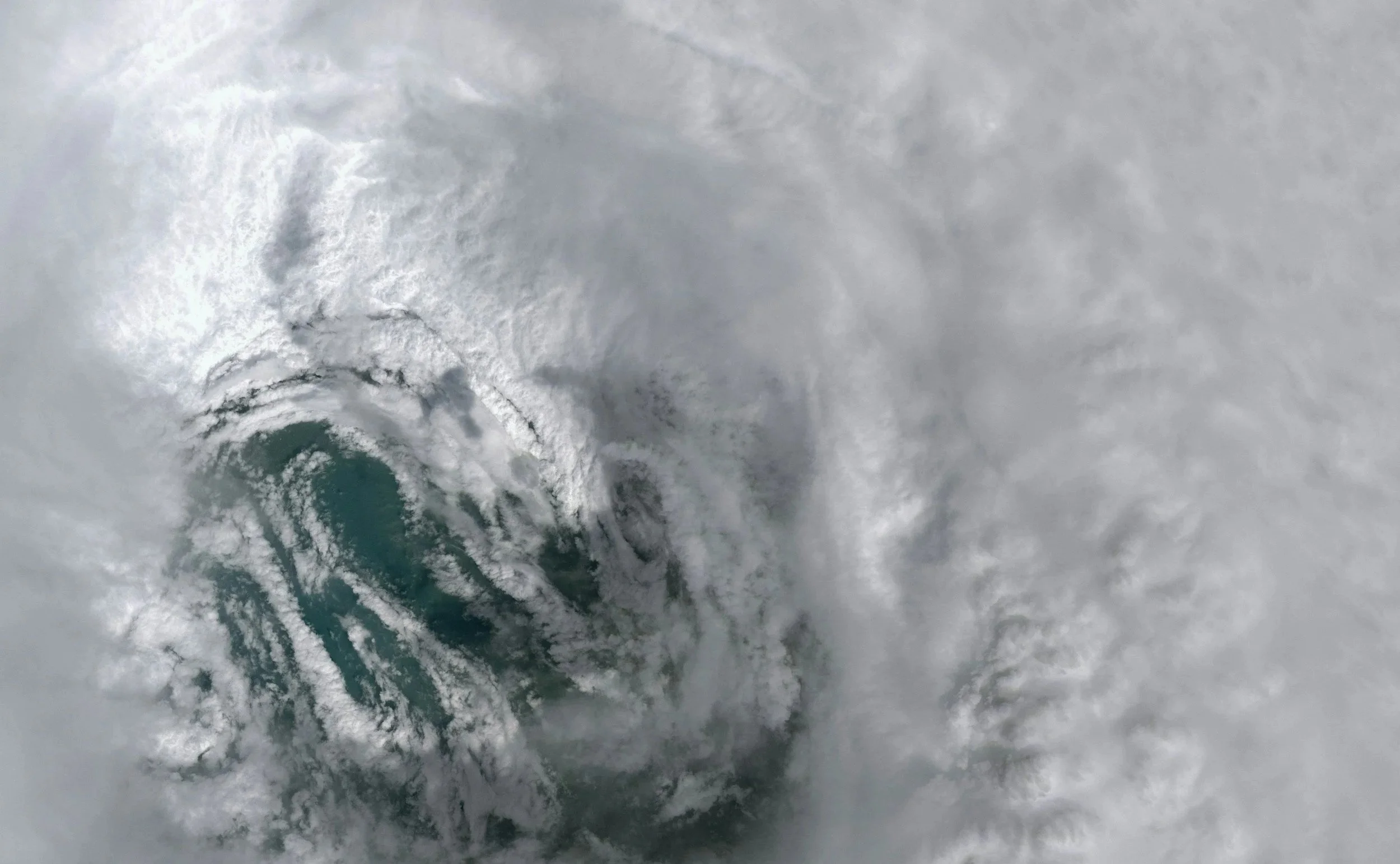 A satellite view looks down into the eye of a tropical storm system over open water, the kind of severe weather event that drives demand for Lima Charlie Inc.'s emergency response housing.
