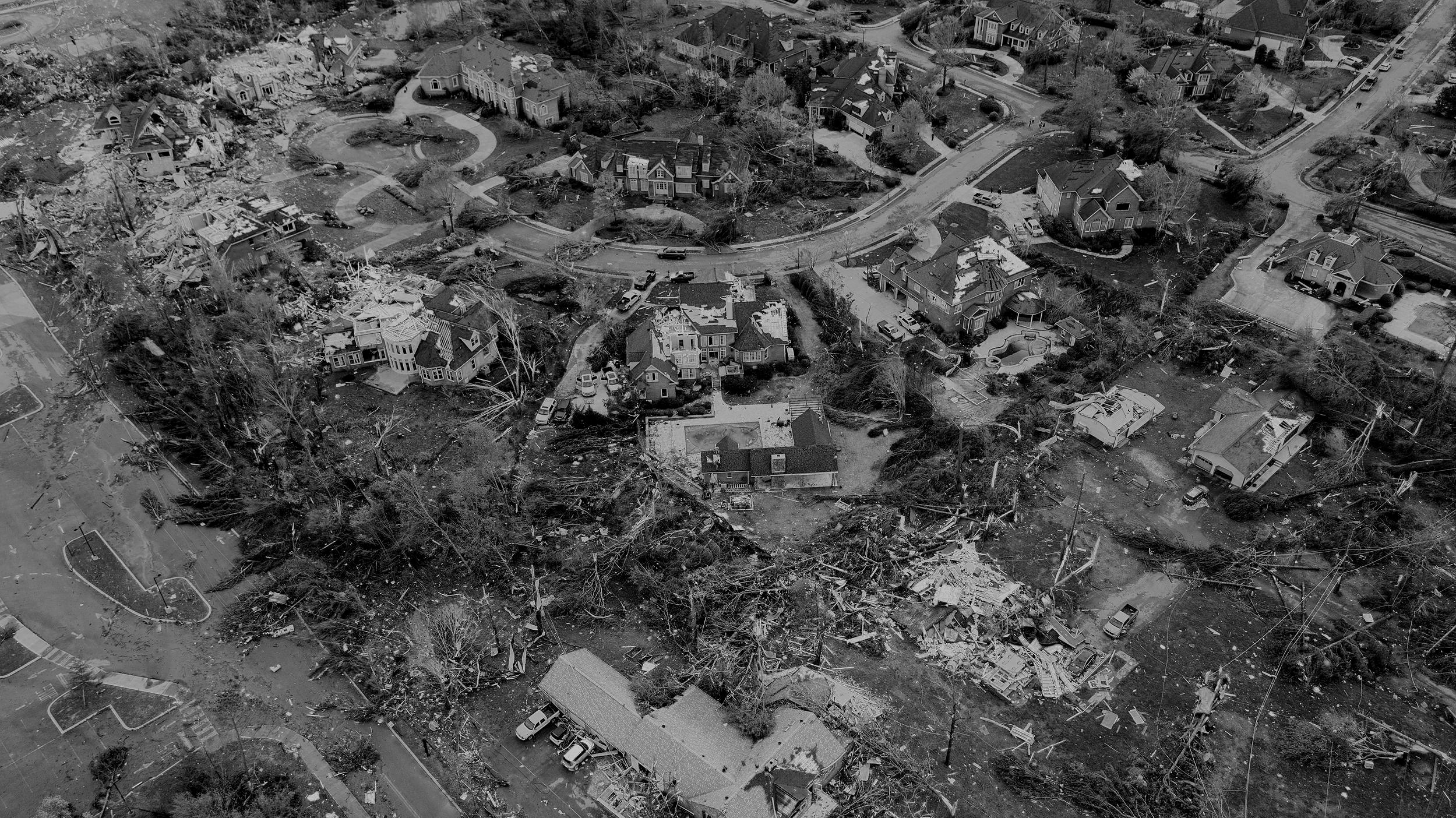 Aerial view of storm damage in a residential area. Lima Charlie Inc. offers temporary housing solutions for displaced residents during disaster recovery.
