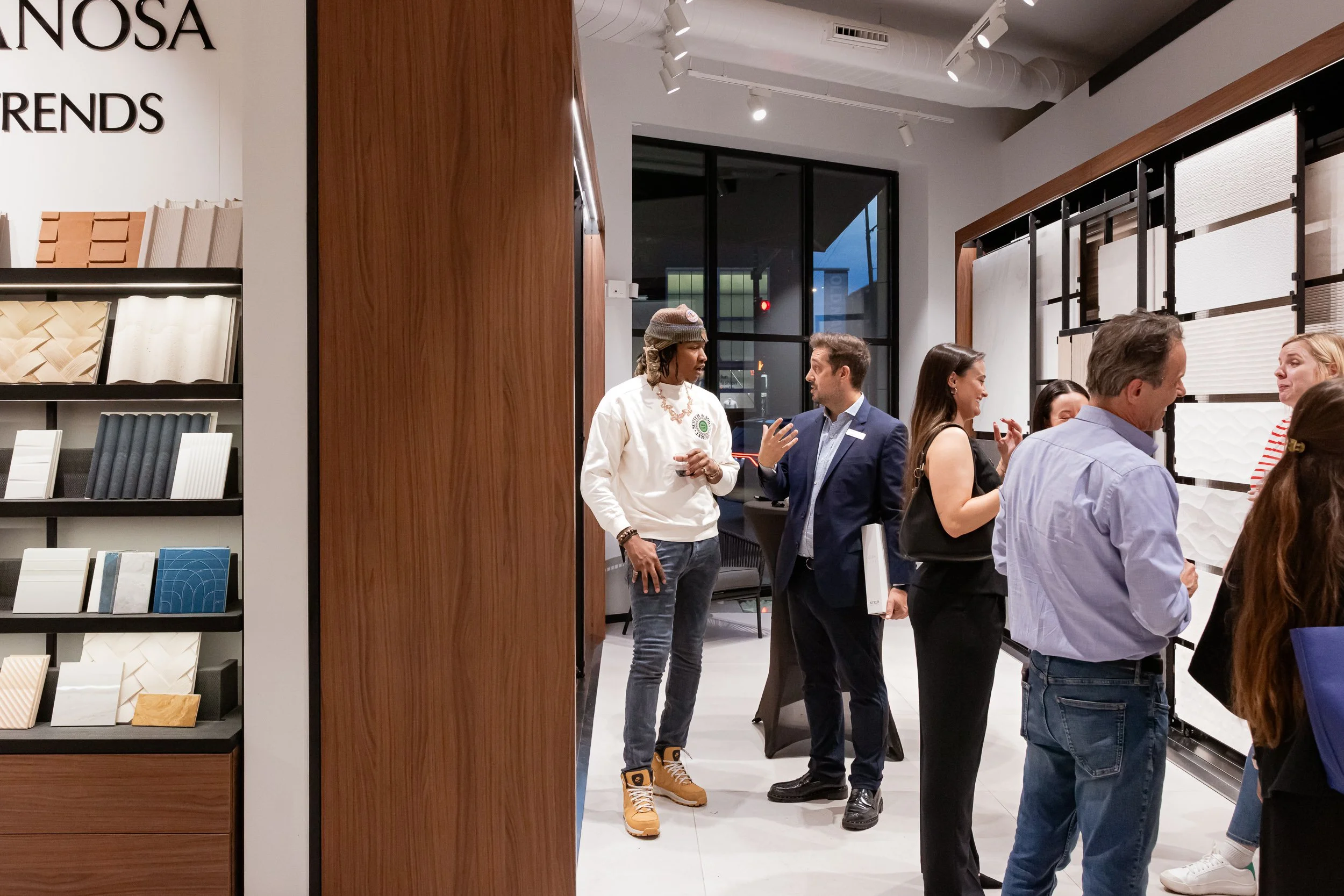 Guests mingling and talking at an indoor corporate event in a modern showroom.