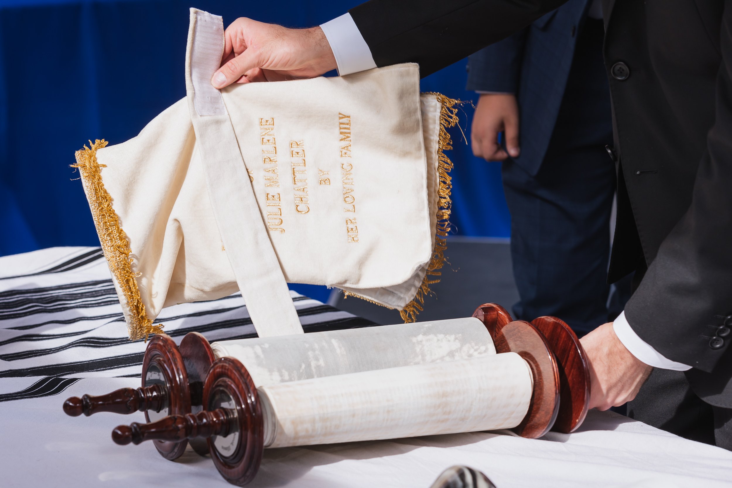 Torah scroll and ceremonial cloth being lifted during a bar mitzvah service.