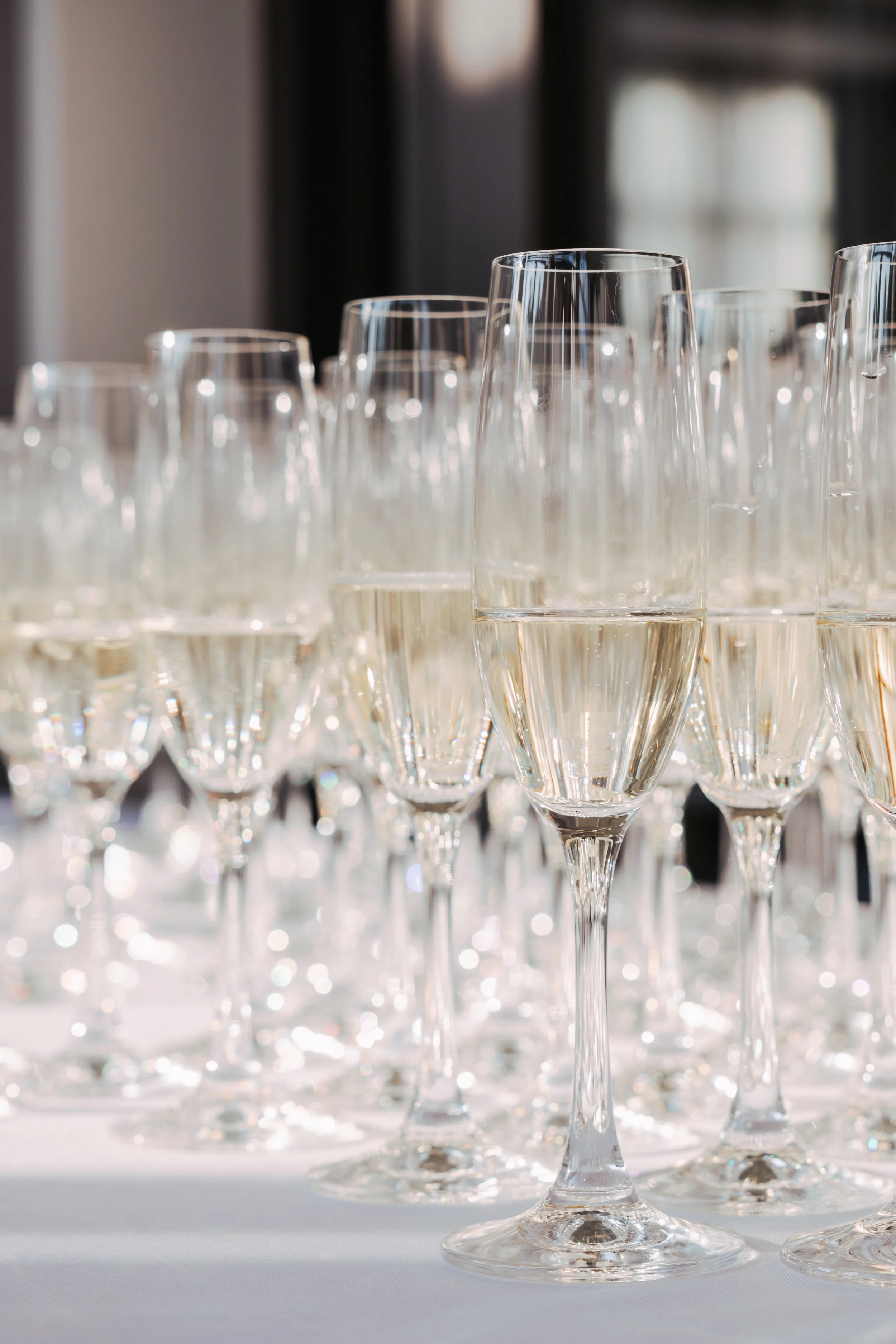 Champagne flutes filled with sparkling wine arranged on a table for an event toast