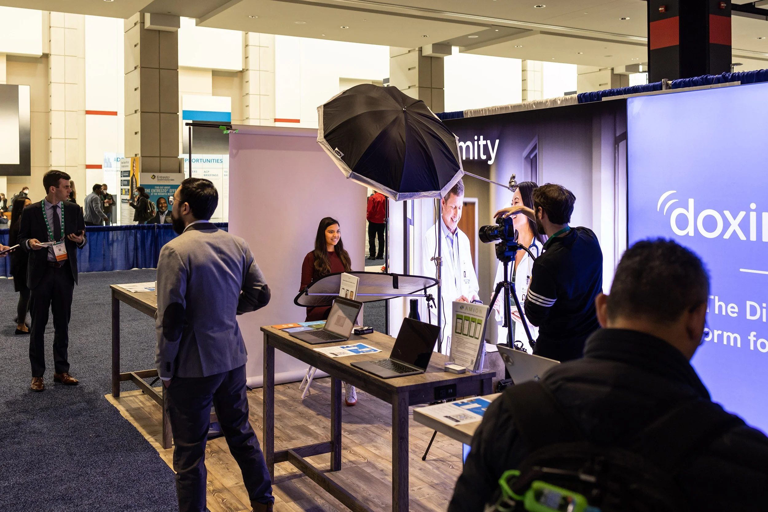 Photography lighting setup at a trade show booth with a photographer taking a headshot.