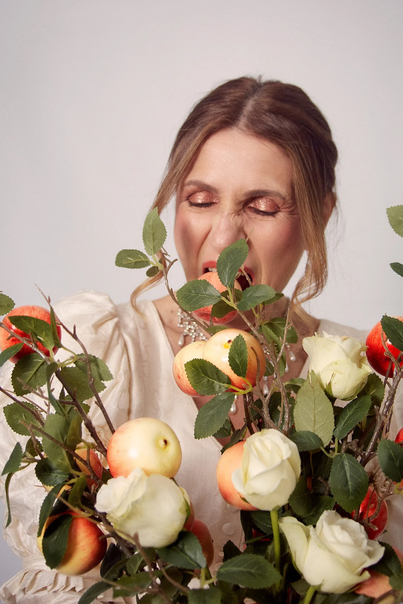 Portrait photograph of La Novia biting an apple in a symbolic gesture from the series Cuerpo Vestido, Alma Desnuda by Beatriz Perez.