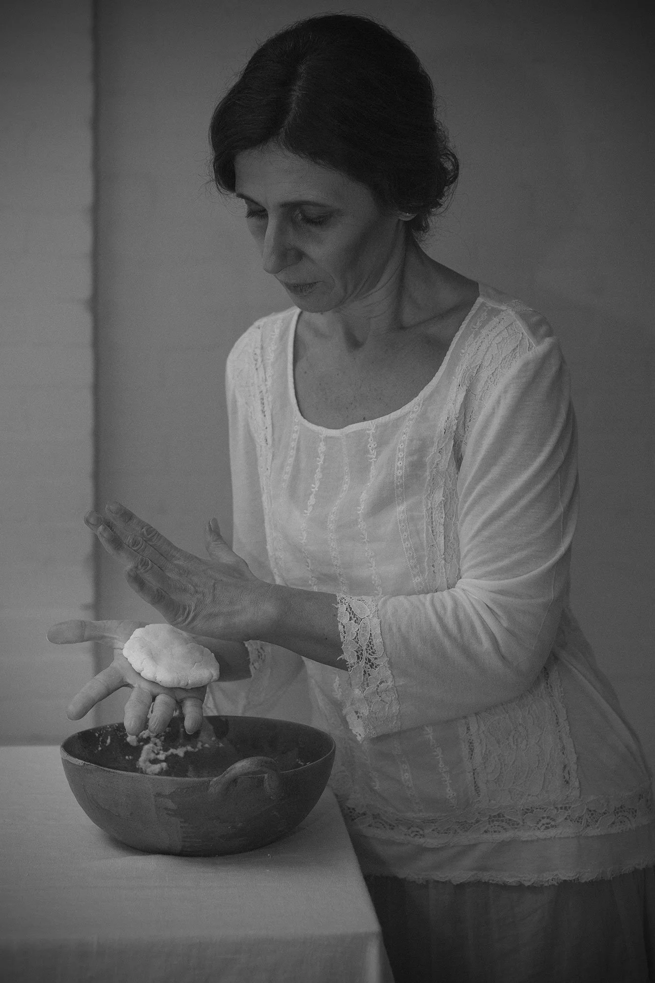 Woman preparing arepas in a domestic kitchen interior from The Weeping Woman series by Beatriz Perez.