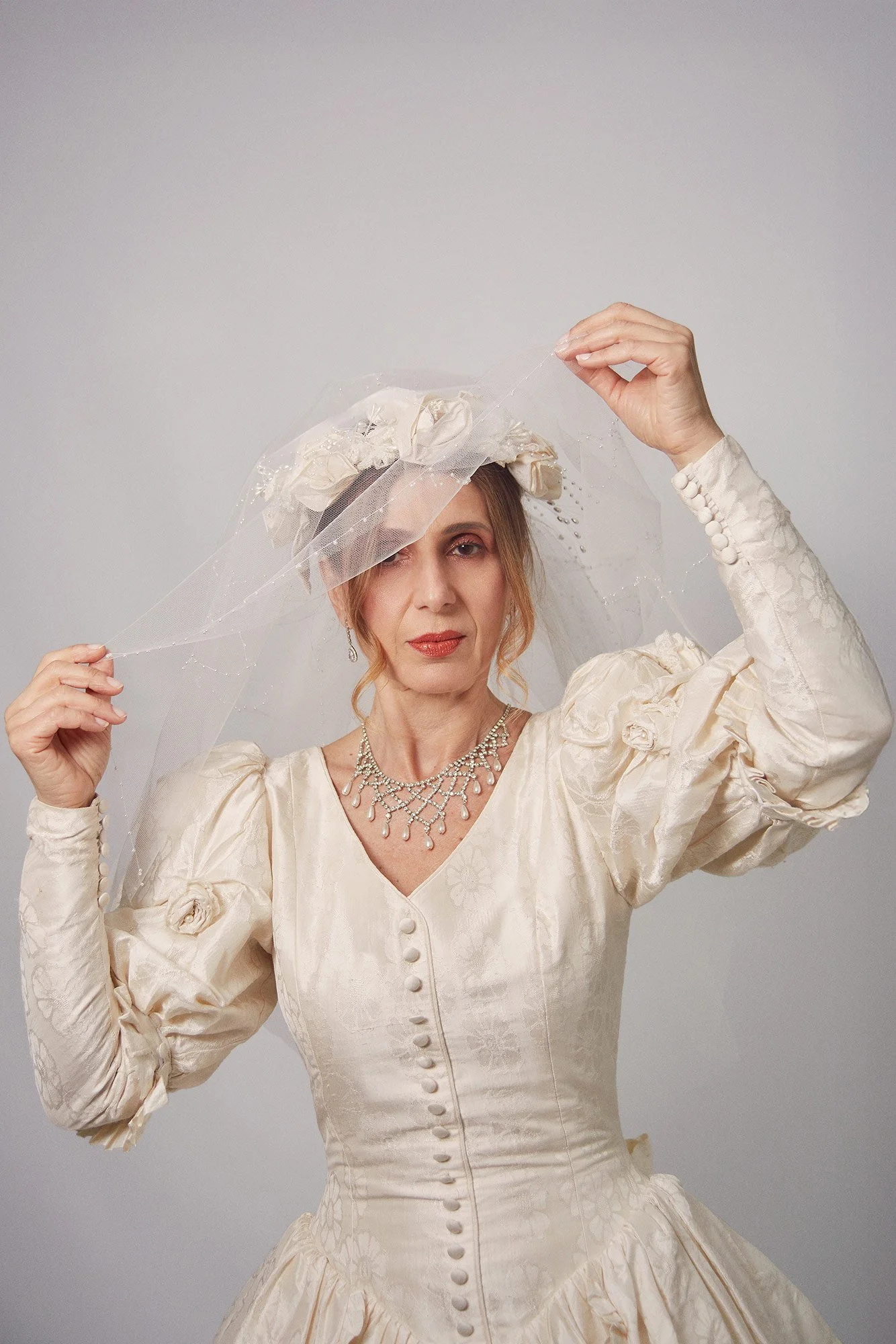 Photograph of La Novia lifting her veil in a symbolic gesture from the series Cuerpo Vestido, Alma Desnuda by Beatriz Perez.