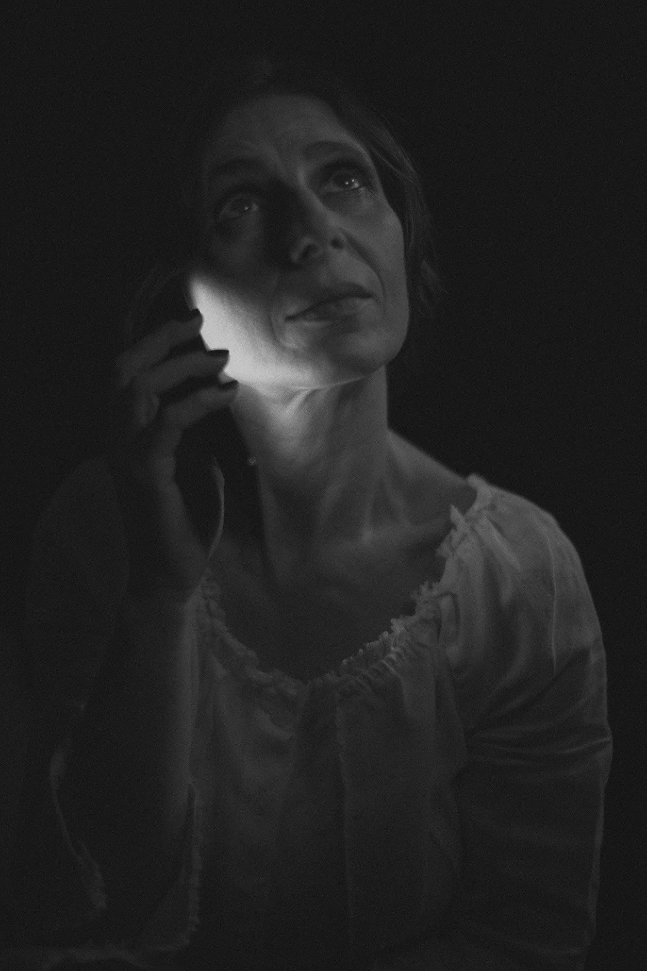 Black-and-white portrait of a woman speaking on a mobile phone from The Weeping Woman series by Beatriz Perez.
