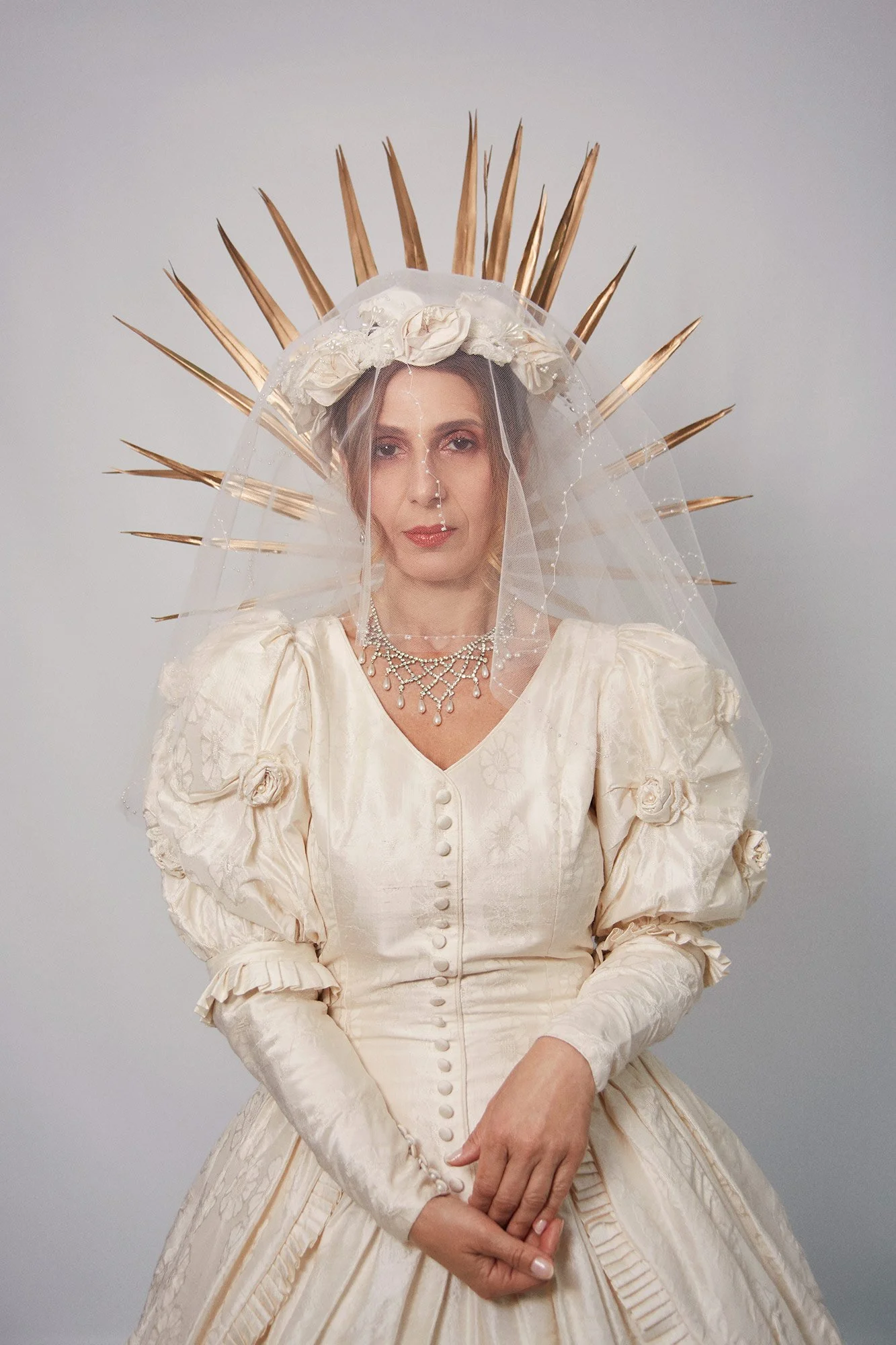 Portrait photograph of La Novia wearing a radiant halo headpiece referencing sacred iconography in the series Cuerpo Vestido, Alma Desnuda by Beatriz Perez.
