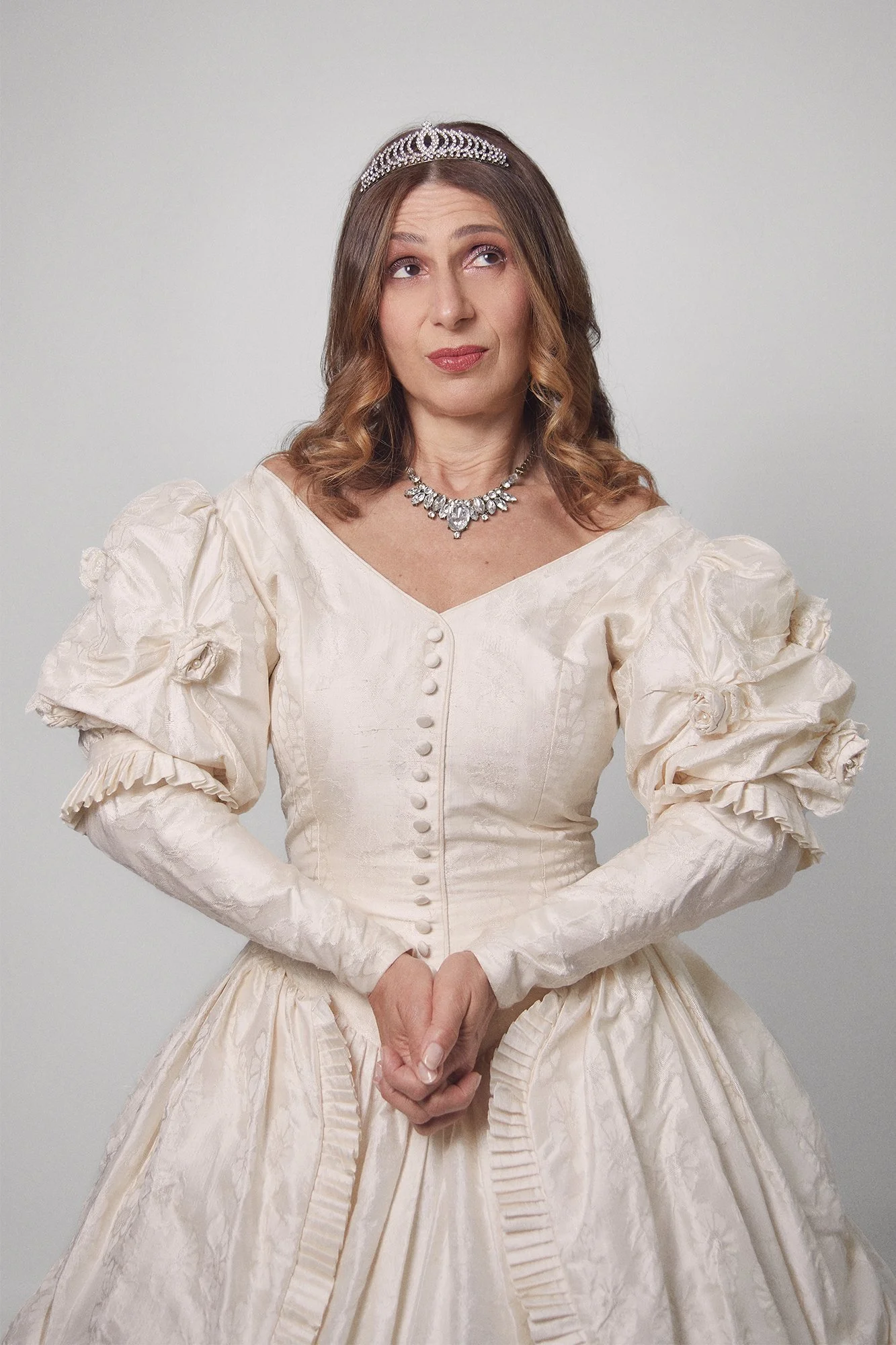 Portrait photograph of La Quinceañera wearing a tiara, poised and contemplative, from the series Cuerpo Vestido, Alma Desnuda by Beatriz Perez.