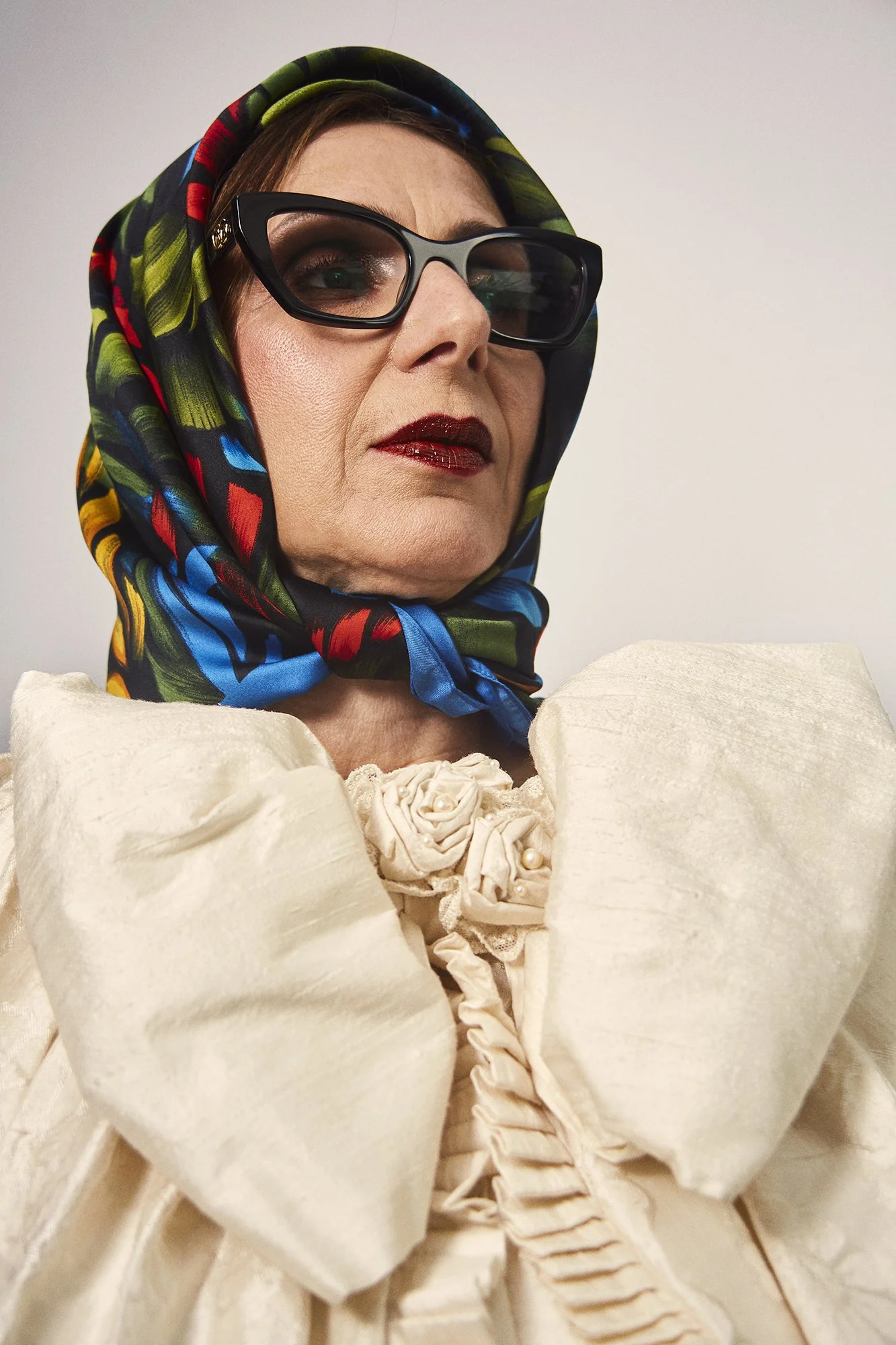 Portrait photograph of La Abuela wearing a headscarf and glasses, embodying memory and lived experience, from the series Cuerpo Vestido, Alma Desnuda by Beatriz Perez.