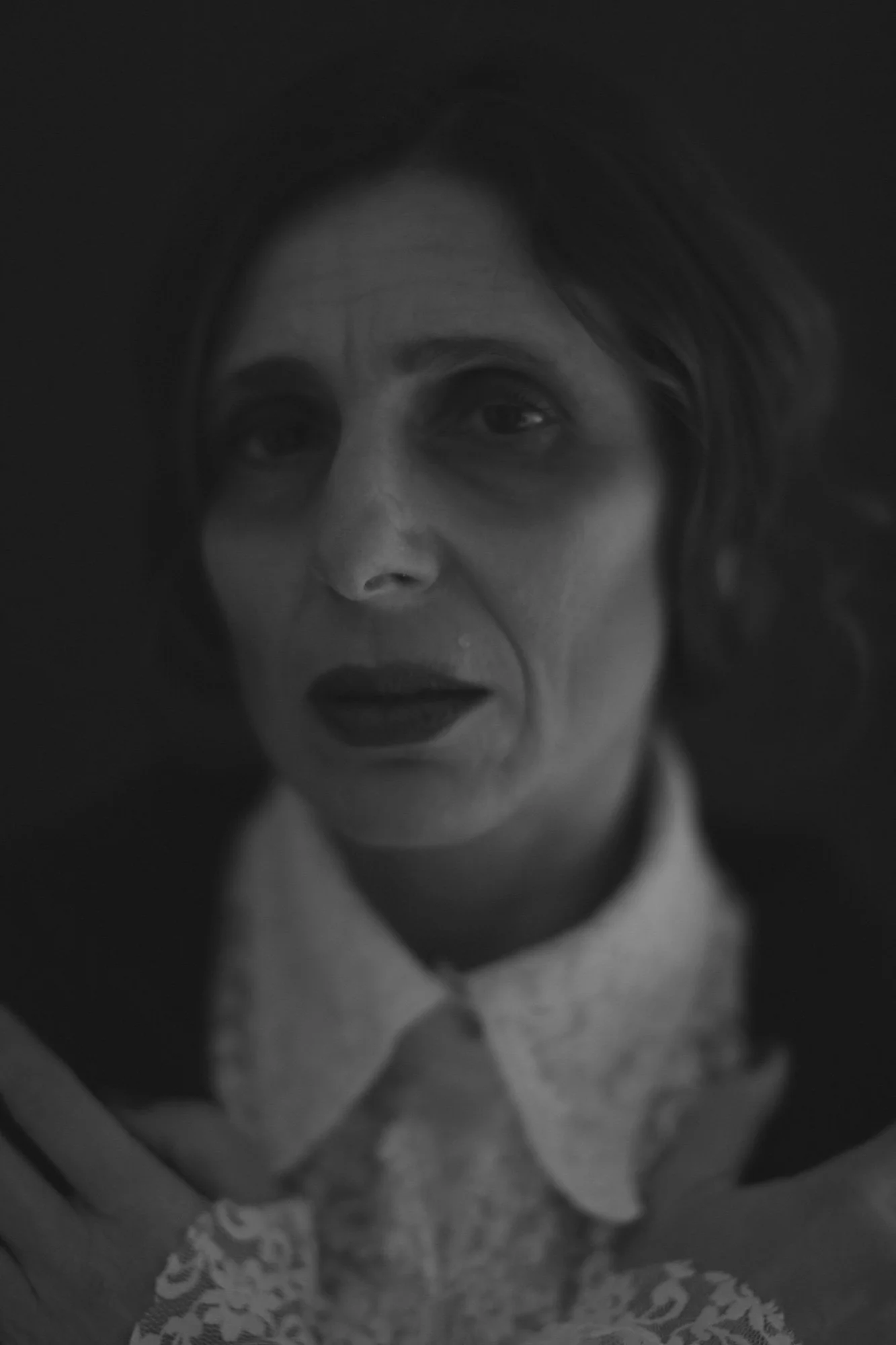 Portrait of a woman with tears in her eyes, crossing her arms over her chest from The Weeping Woman series by Beatriz Perez.