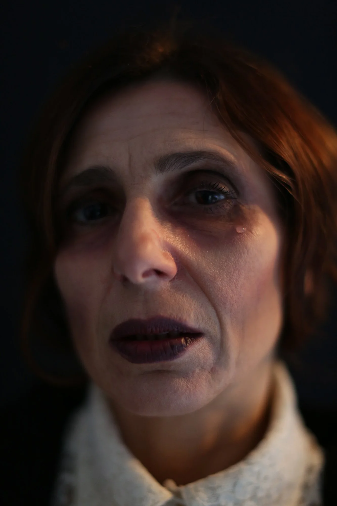 Close-up portrait of a woman with a tear on her face from The Weeping Woman series by Beatriz Perez.