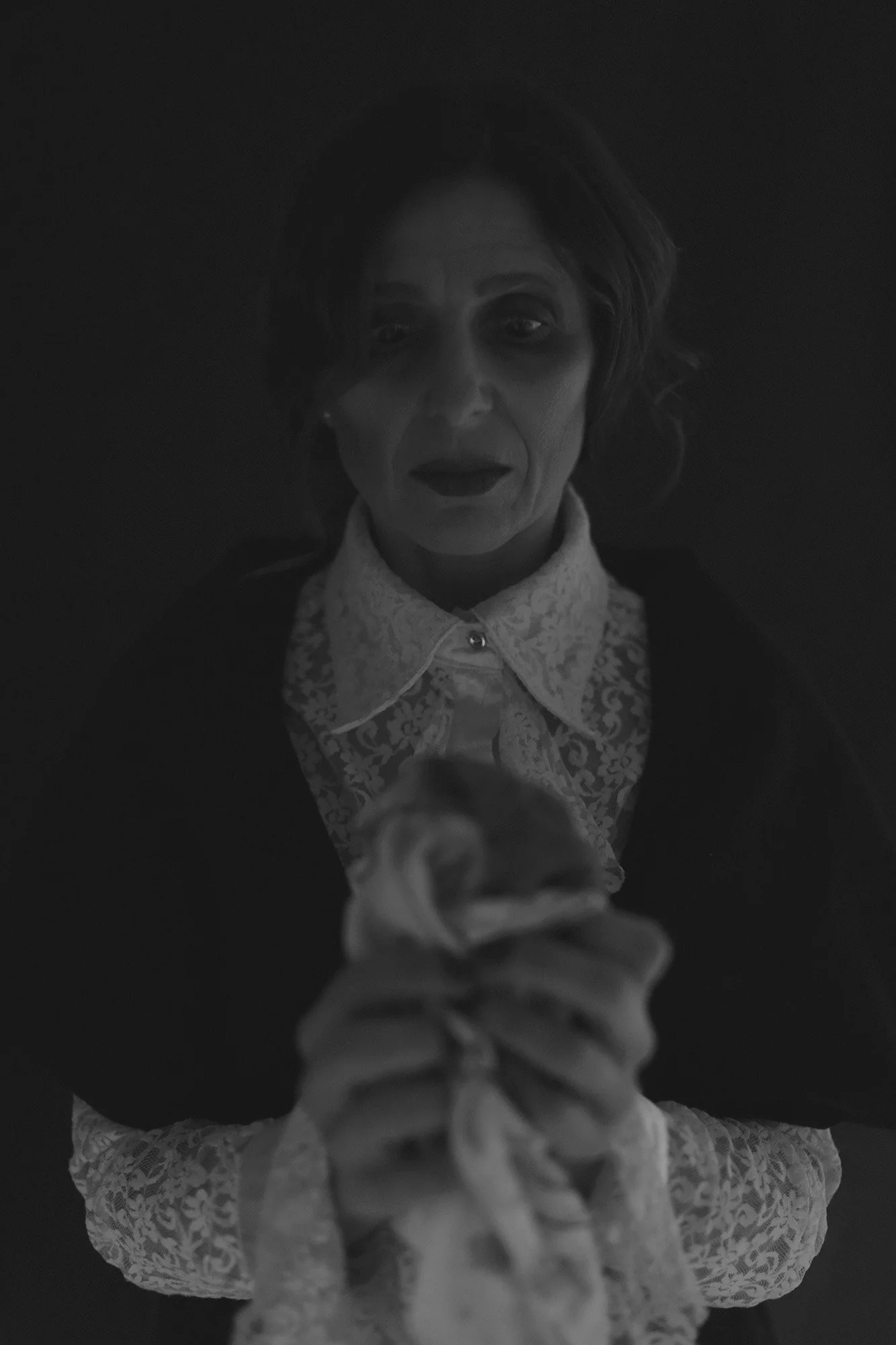 Woman holding a white T-shirt stained with blood in a symbolic portrait from The Weeping Woman series by Beatriz Perez.