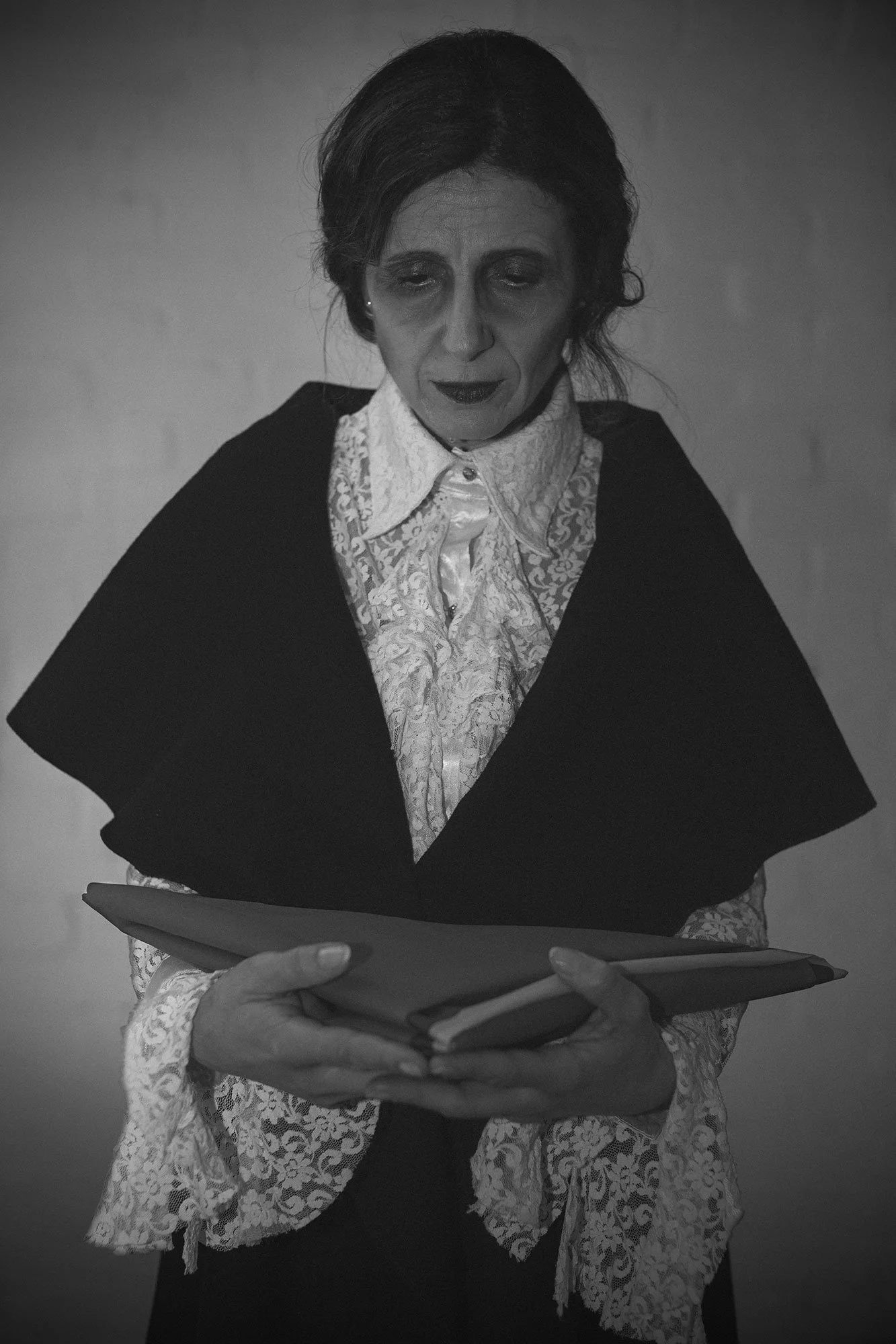 Distressed woman holding a folded Venezuelan flag in a portrait from The Weeping Woman series by Beatriz Perez.