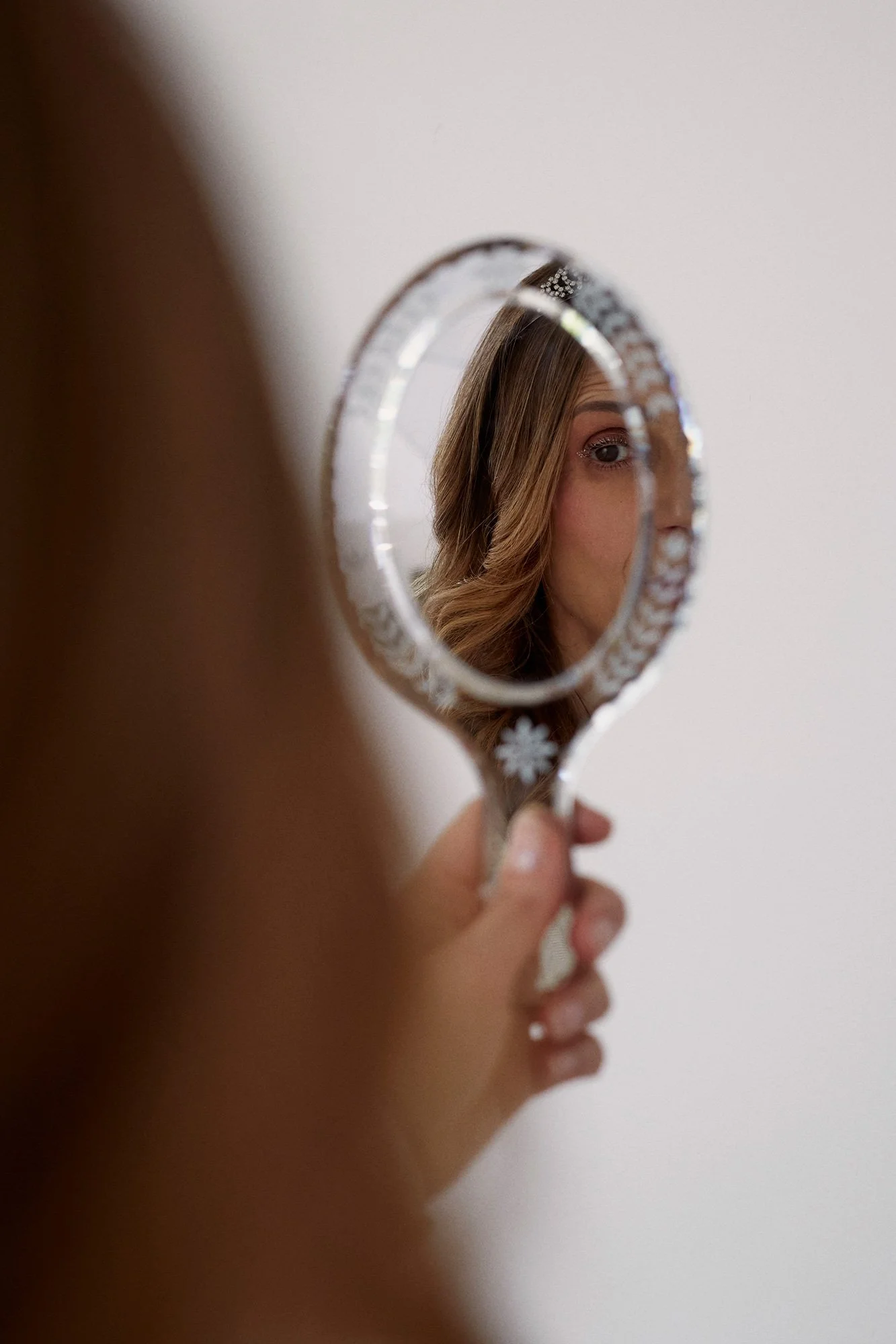 Photograph of La Quinceañera holding a mirror showing her reflection from the series Cuerpo Vestido, Alma Desnuda by Beatriz Perez.