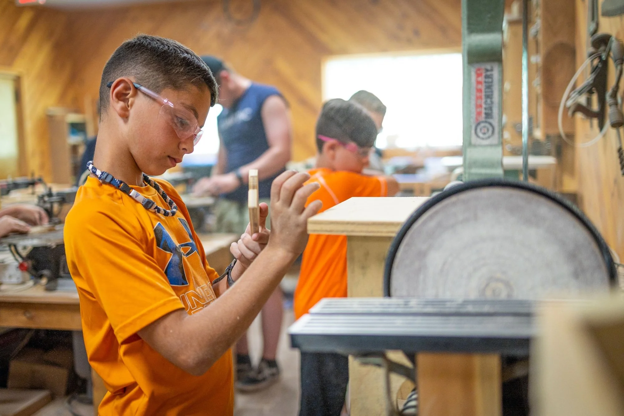 Children working with woodworking tools in a workshop.