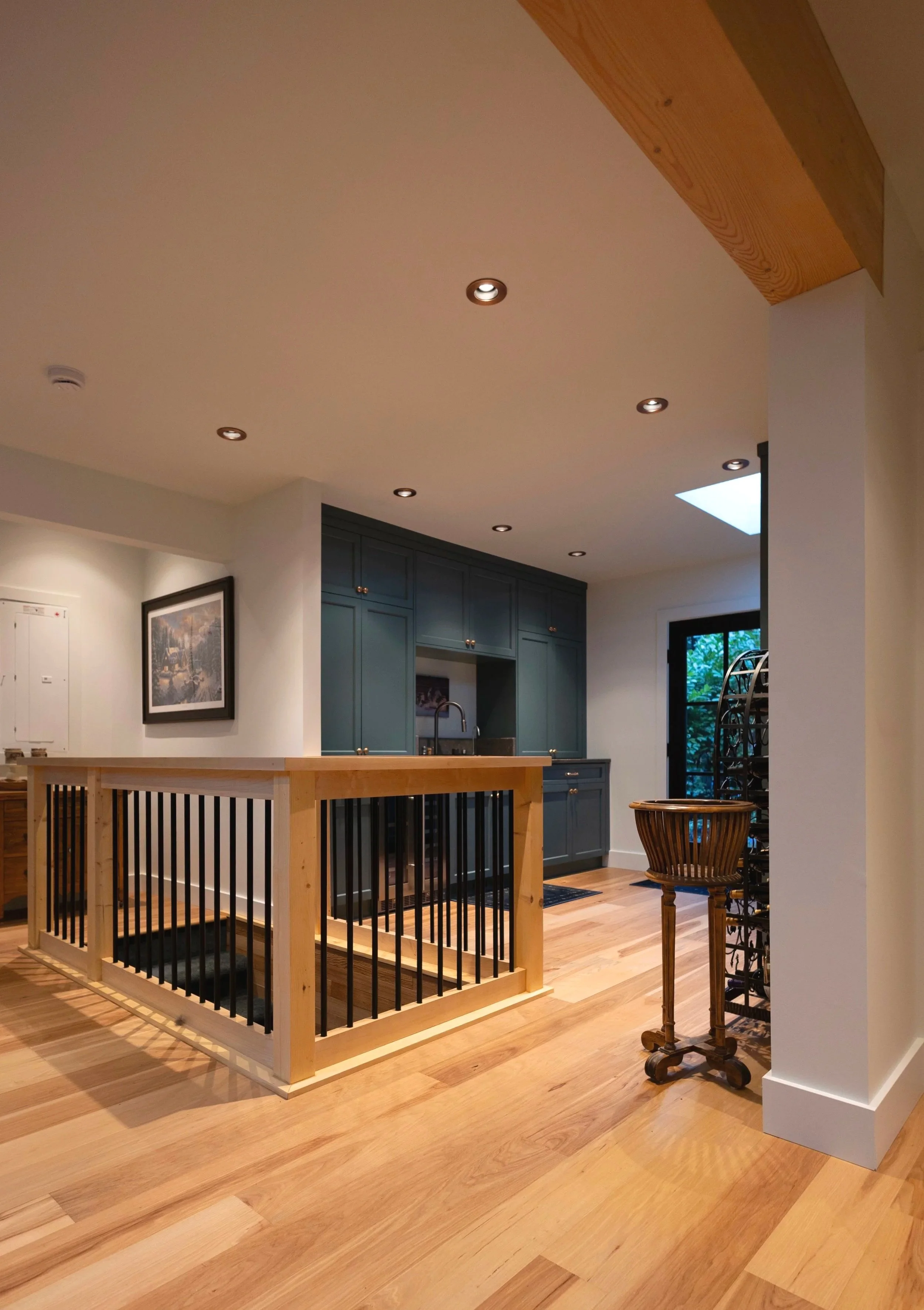 Kitchen extension with custom railing to the basement, oak hardwood, and green cabinets for extra storage. 