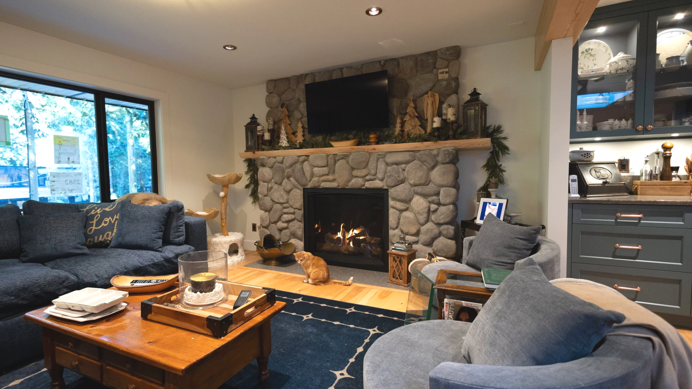 Living room with large custom stone fireplace and live edge mantel.