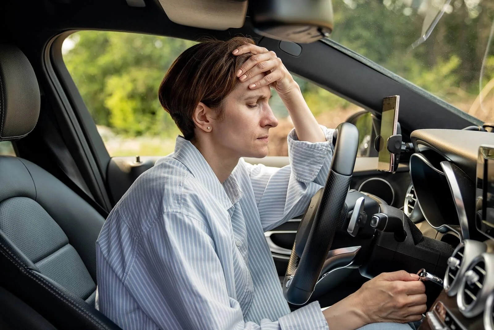A woman sits overwhelmed in her car, reflecting what happens when the EMDR process moves too fast. An EMDR therapist in St. Paul, MN keeps clients grounded throughout treatment.