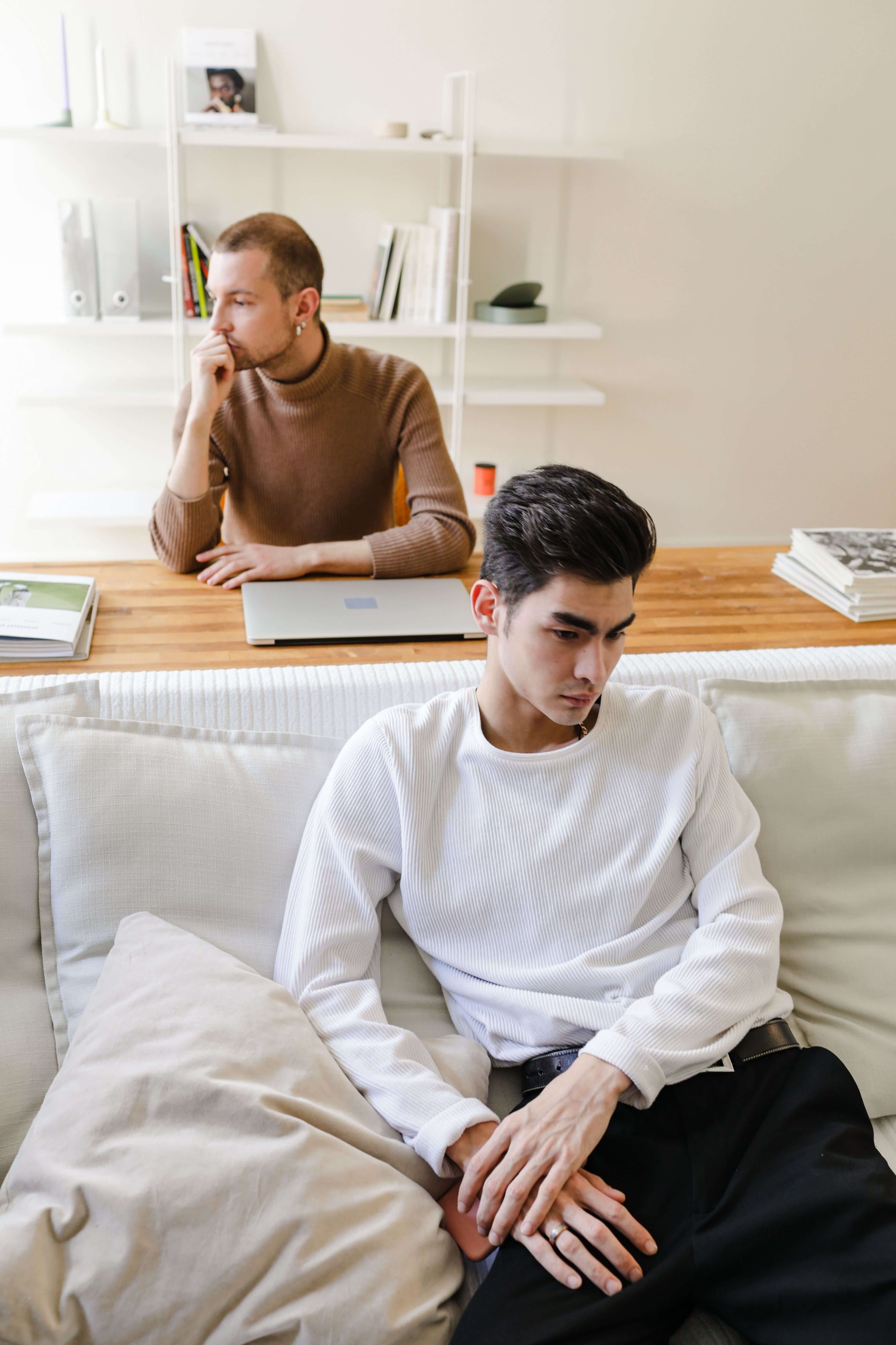 Two men sit apart and turned away, the quiet distance of a strained relationship between them. Substance abuse counseling in St Paul, MN, a couples therapist in Saint Paul, MN, or a relationship therapist in St Paul, MN can help partners reconnect.