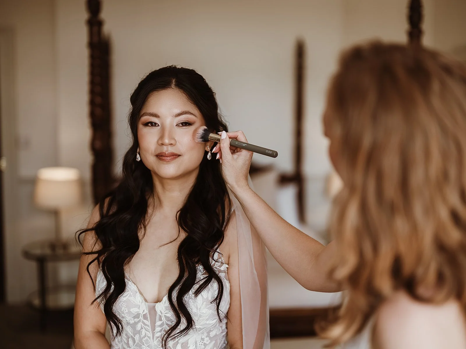 a bride having her final makeup touch-ups on her wedding day