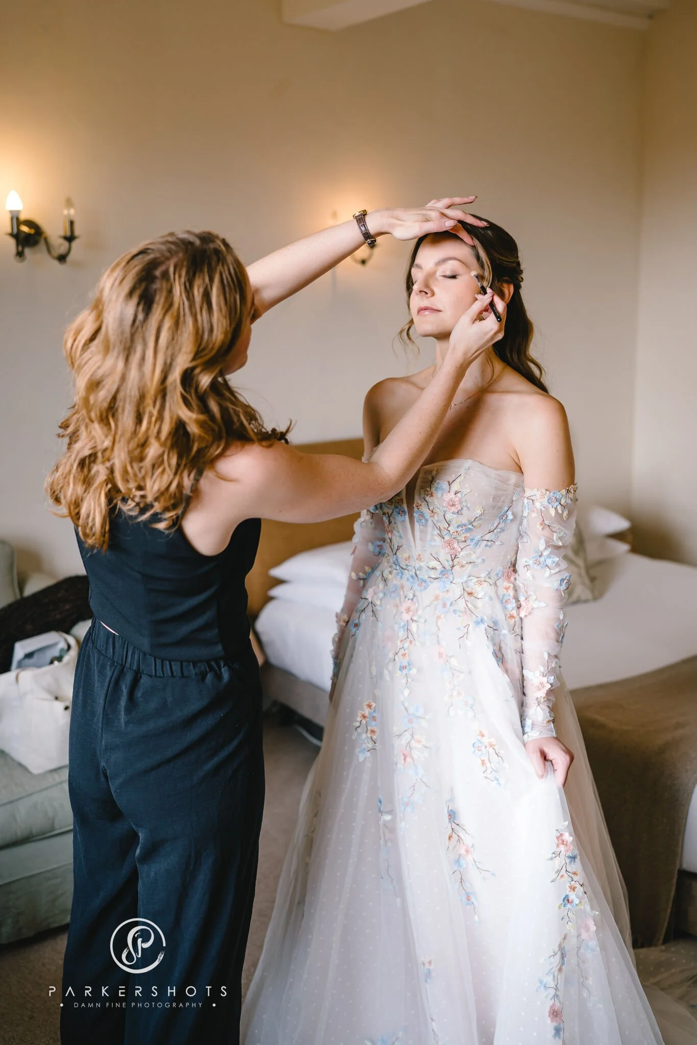 Bride having final makeup touch-ups on her wedding morning in Kent