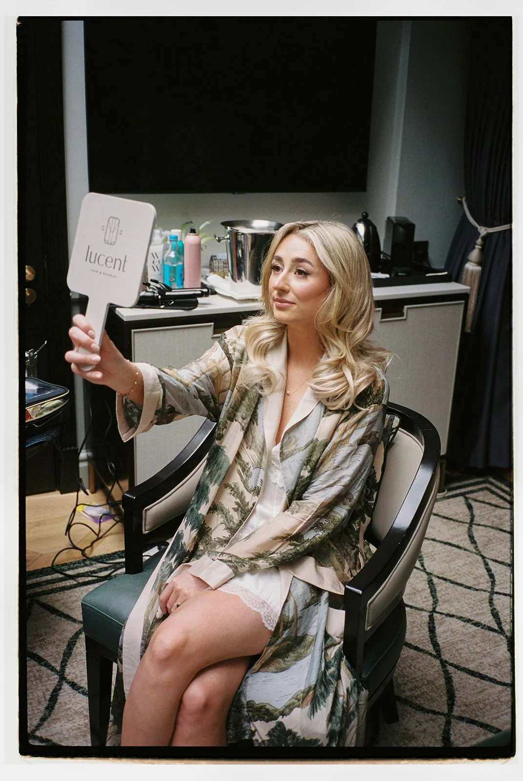 Bride looking at her reflection in the mirror to see her bridal makeup on her wedding morning